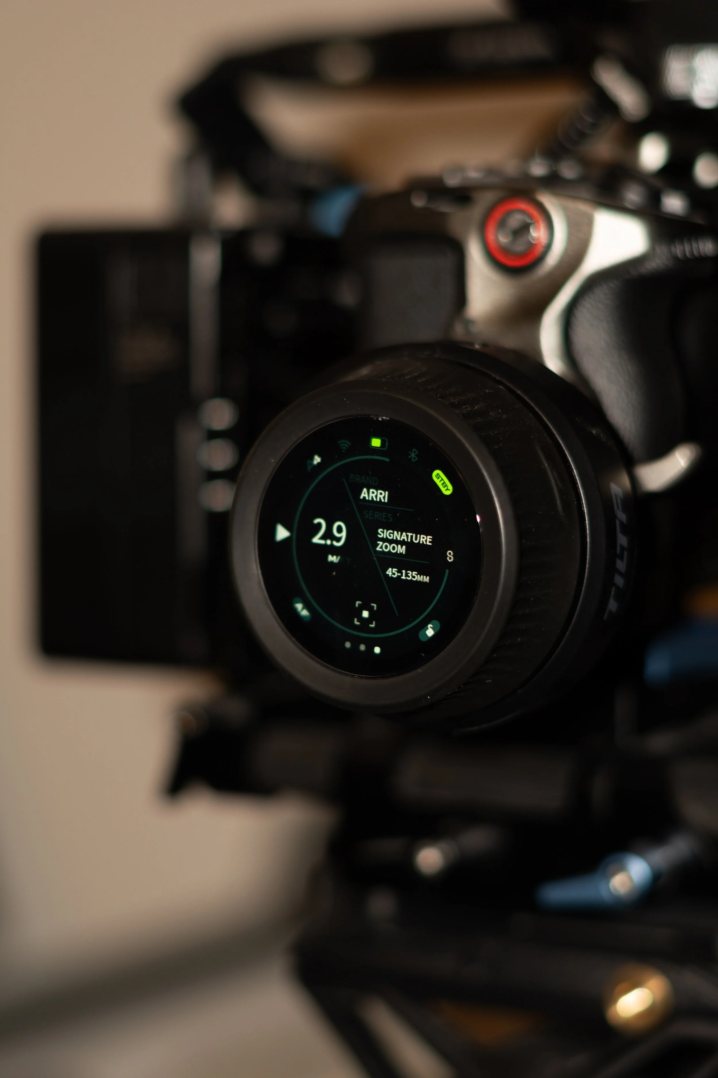 Close-up of a camera lens displaying ARRI branding, zoom setting at 2.9 meters, with a blurred camera body and background.