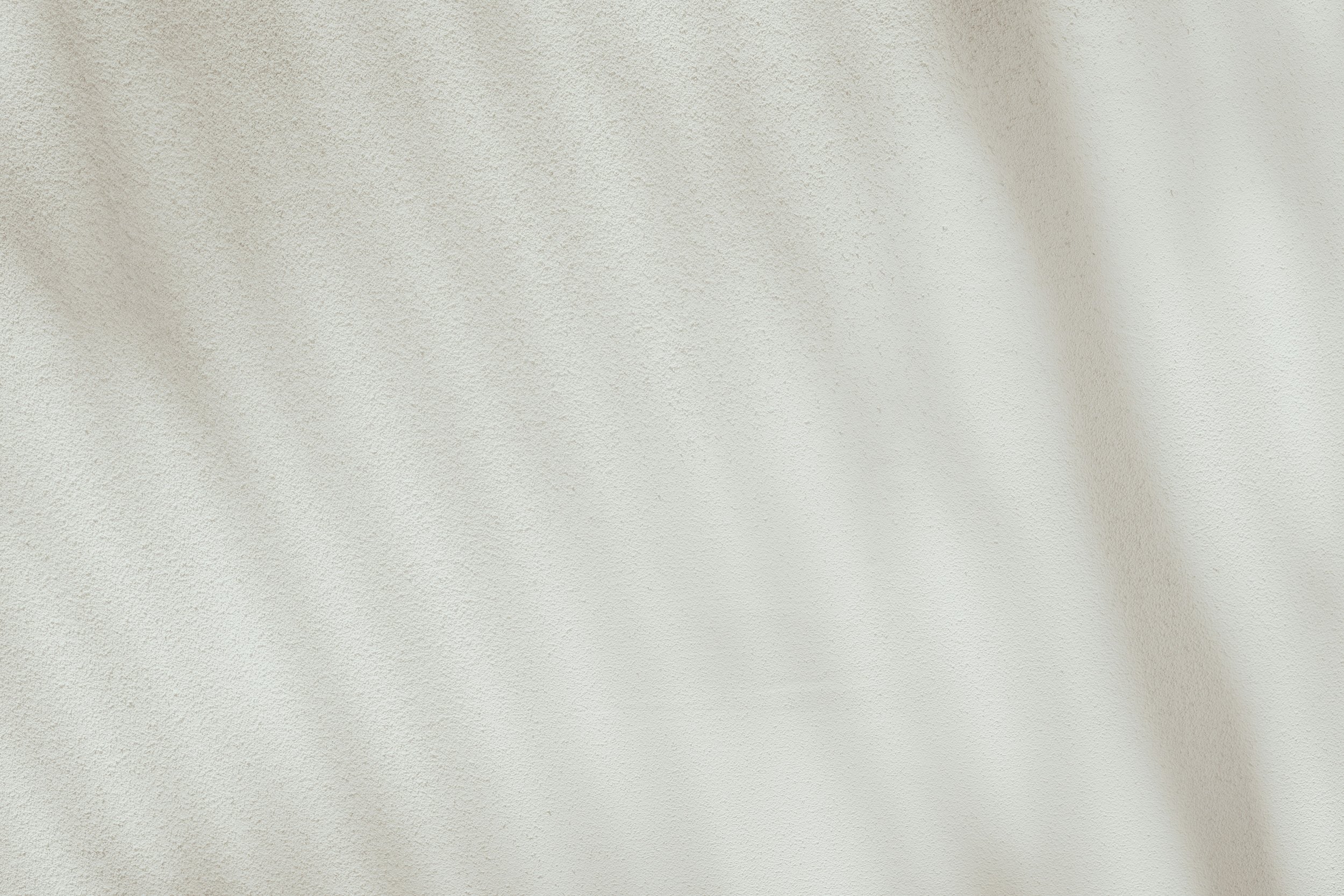 Close-up view of a textured beige or light-colored wall.