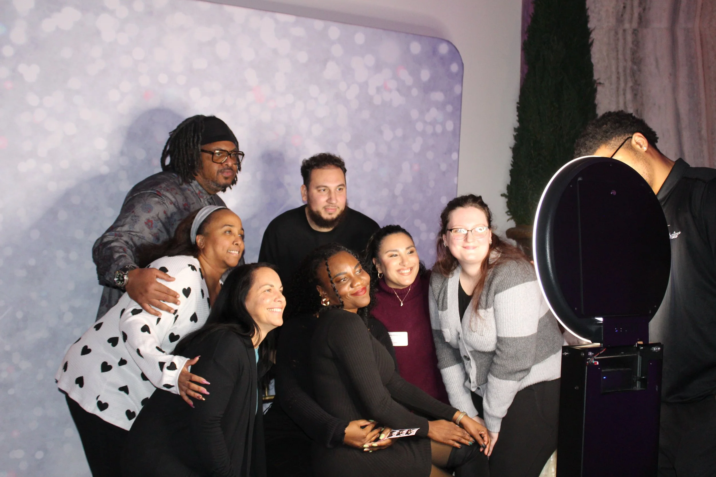 Large group of Acenda employees pose for a photo in photo booth