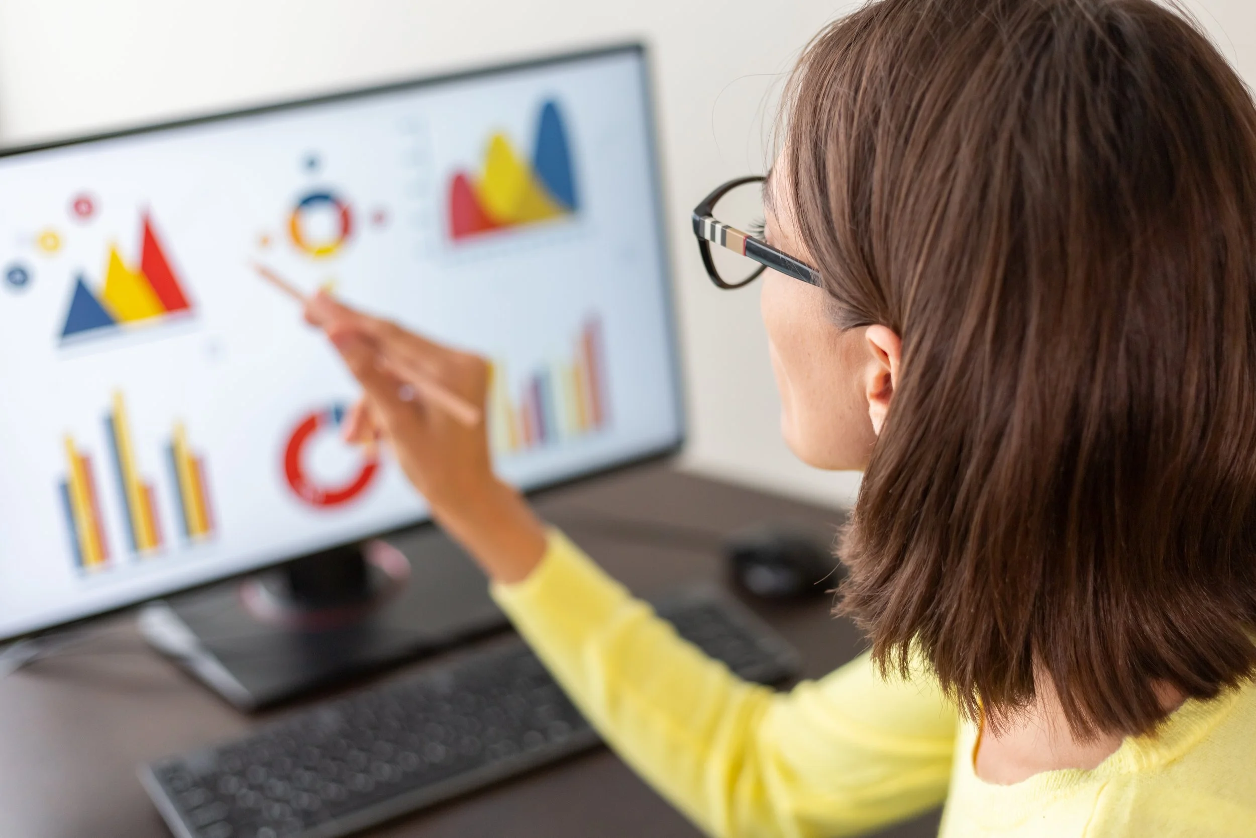 woman looking at analytics graphics on computer monitor