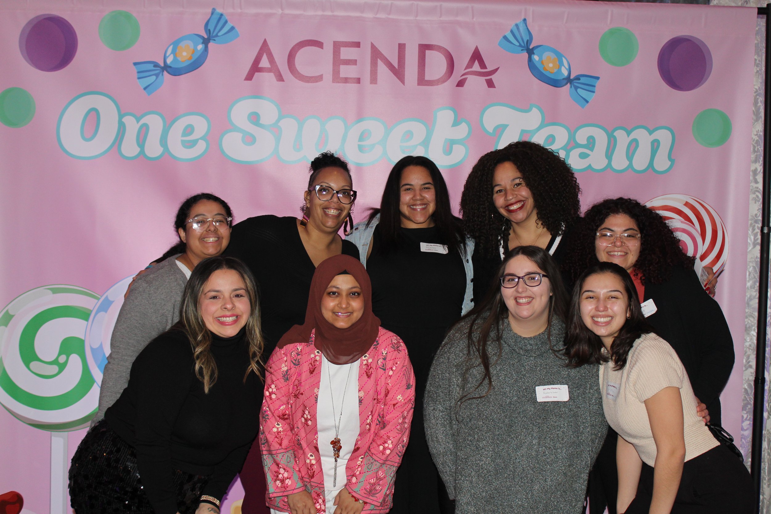 Large group of Acenda employees pose in front of a "One Sweet Team" backdrop for Staff Bash 2026