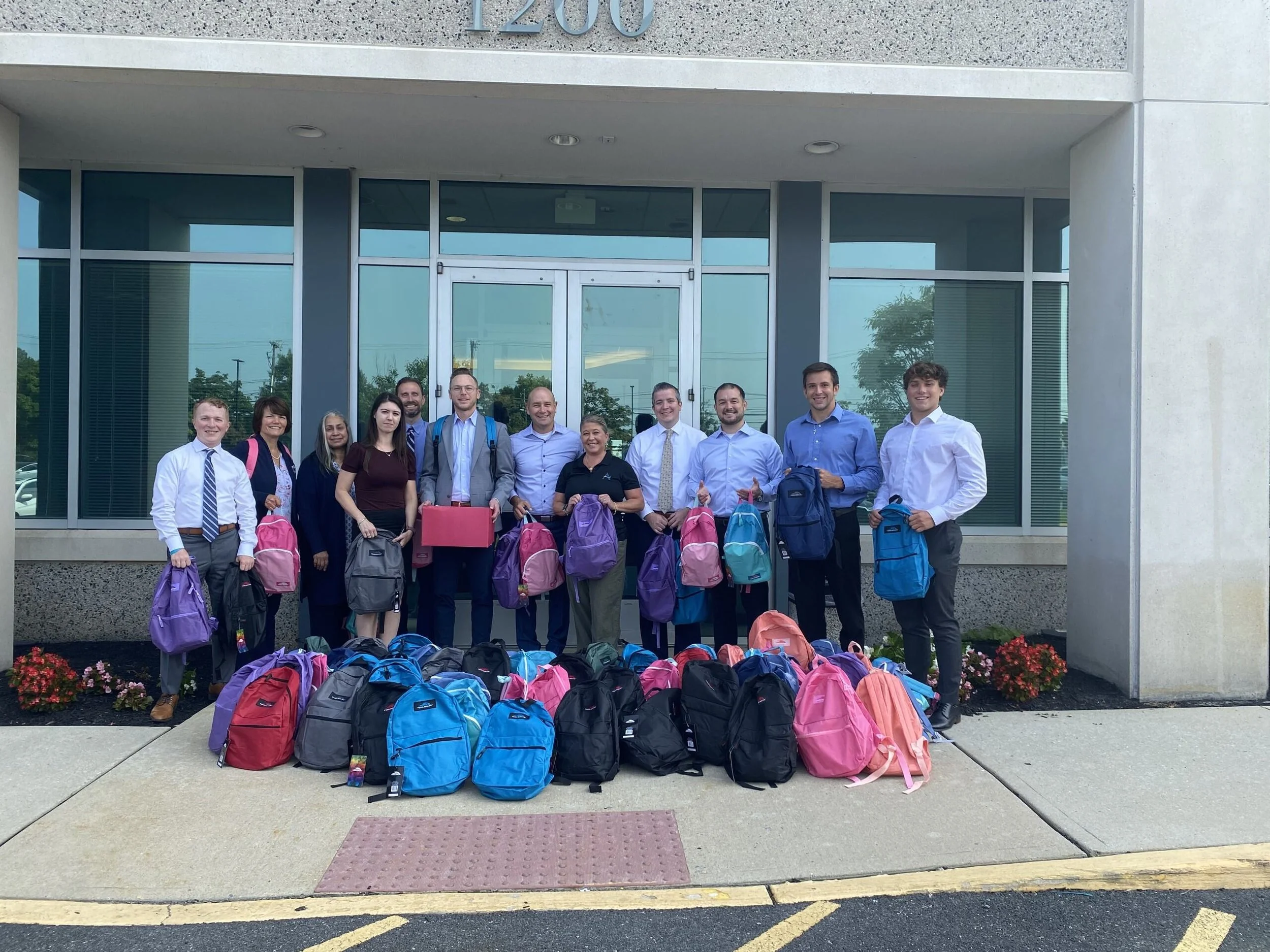Corporate donors post with their backpack and school supply donations for Acenda