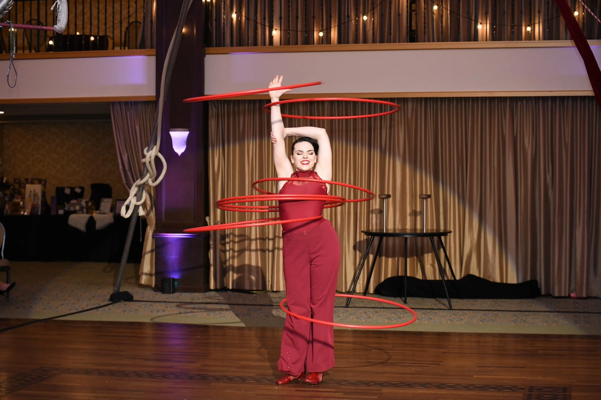 female performer dress in red at Acenda's Le Cirque event shows off her hula hooping skills