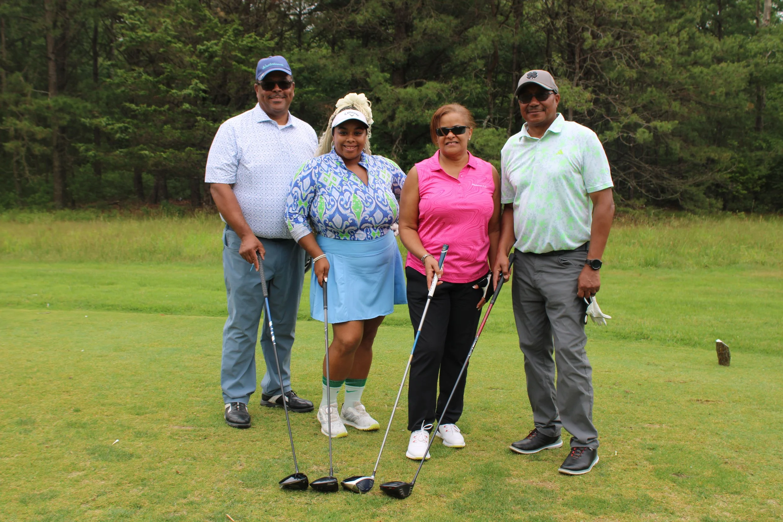 group of four golfers pose at Acenda's Golf Classic