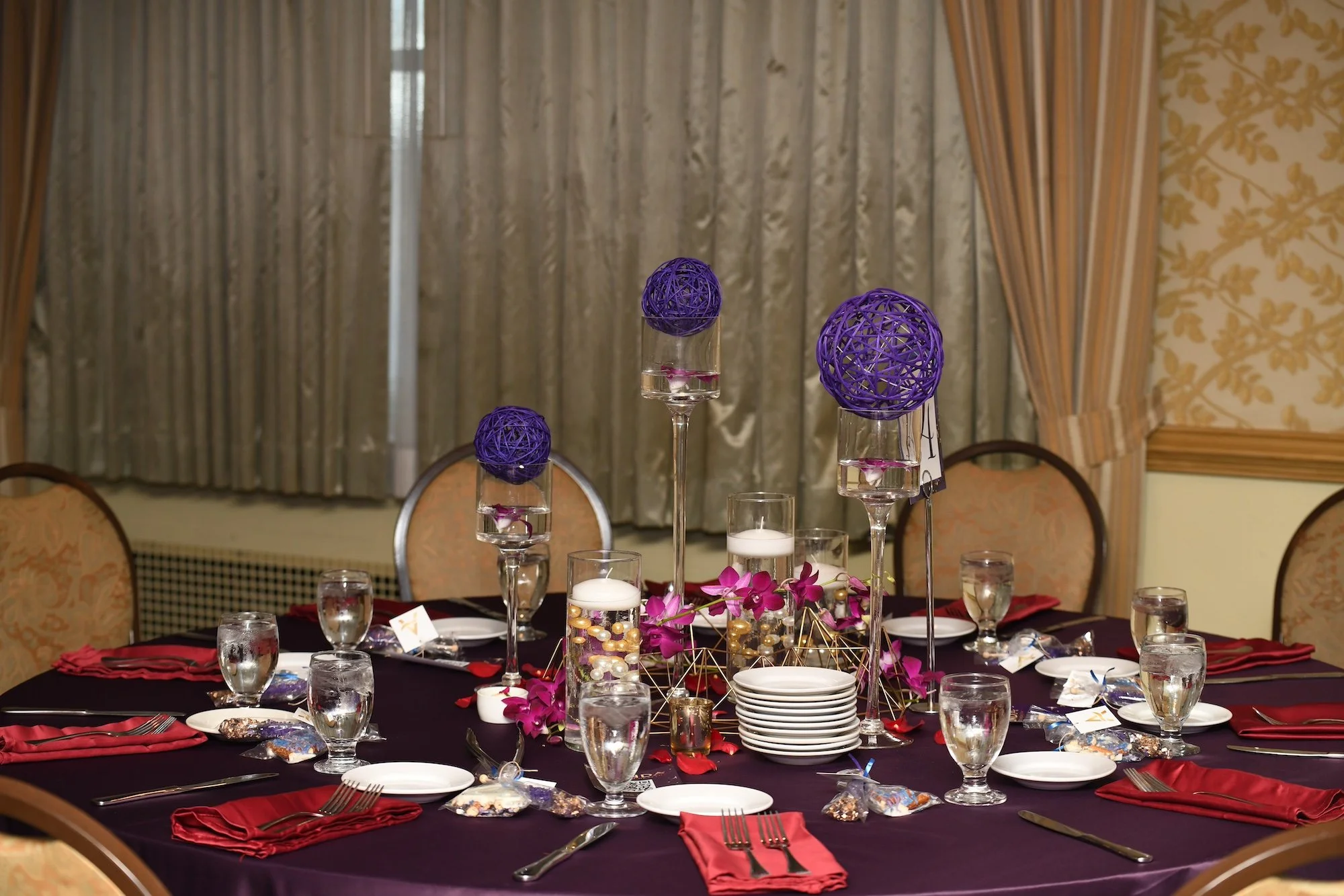 2024 Le Cirque table decor featuring candles, fuchsia flowers and purple accents