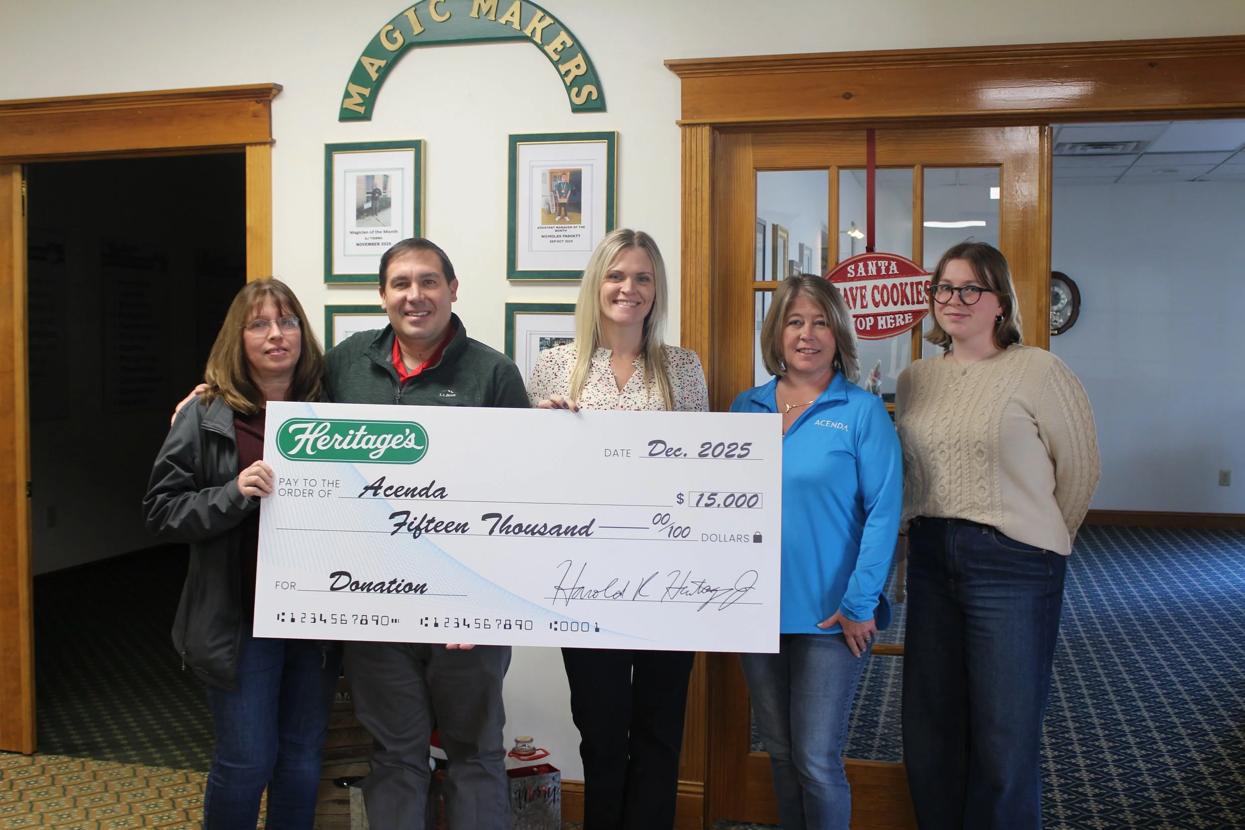 Acenda staff stand with donors from Heritages Dairy to receive Spirit of the Holidays donation