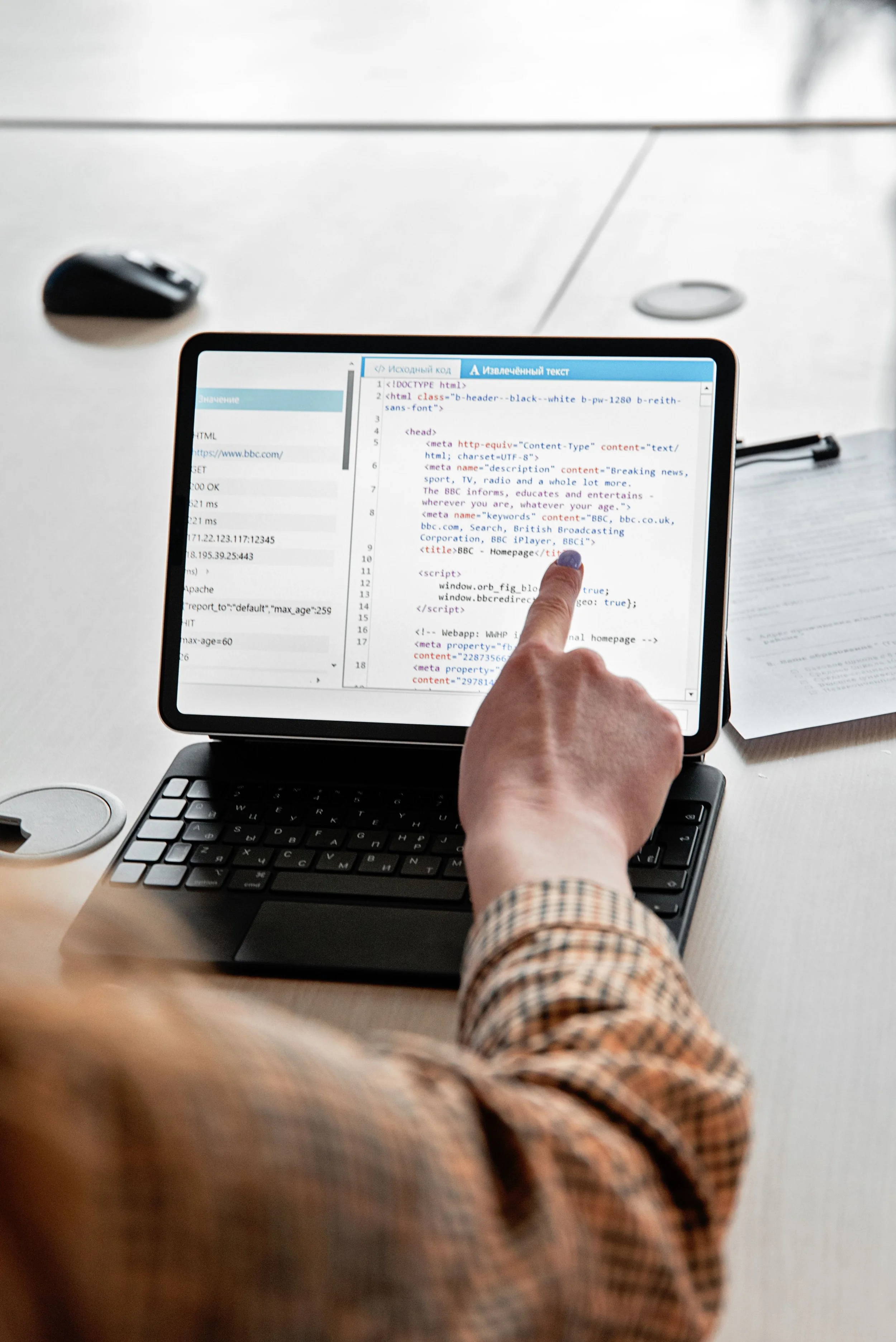 office employee reviewing website code on a small black laptop