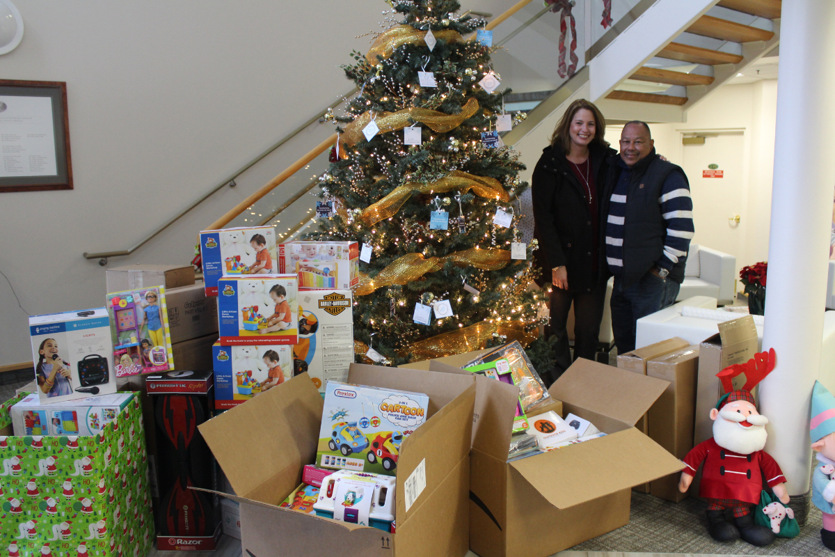 Spirit of the Holidays donors pose with large toy donation for Acenda clients