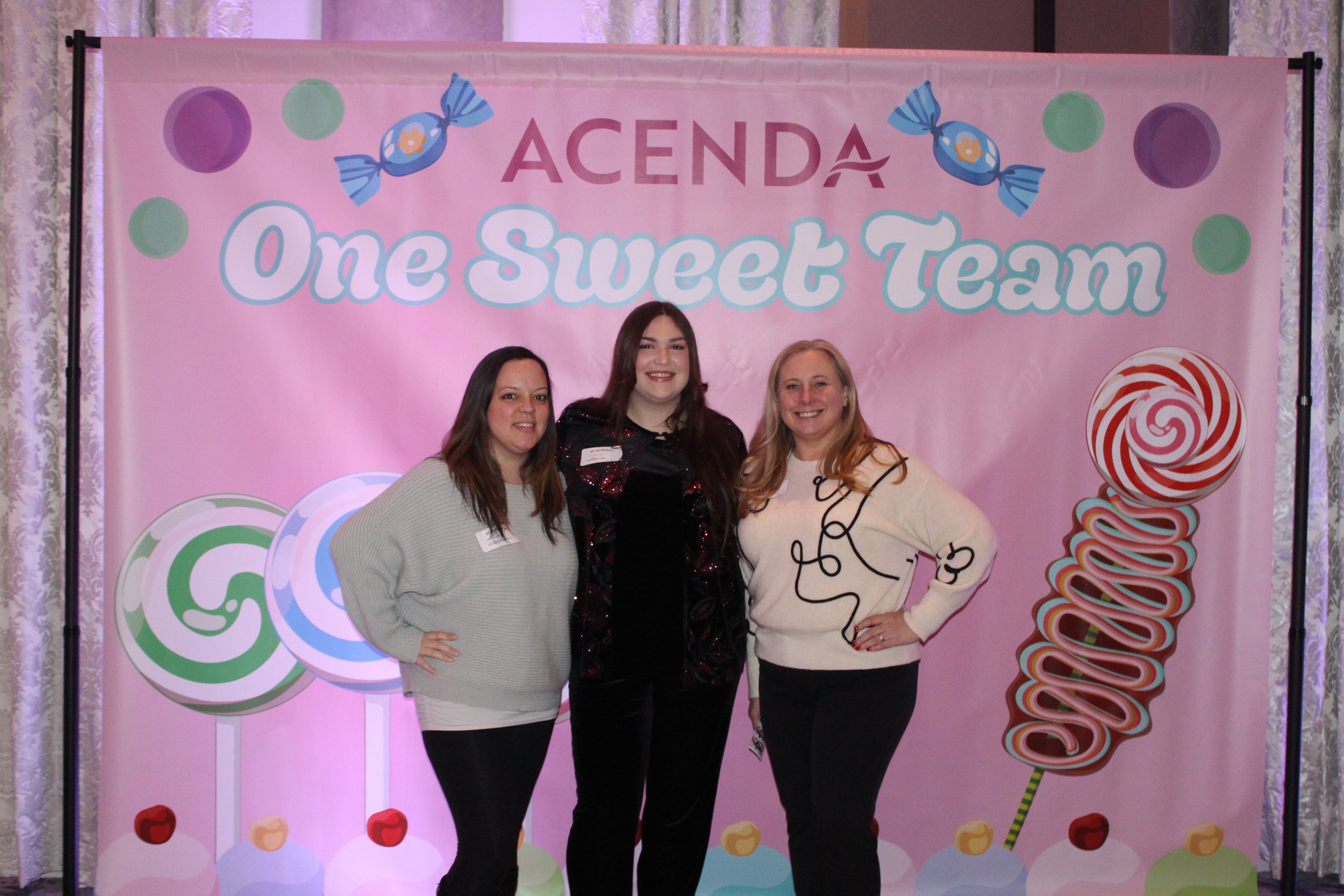 three Acenda staff stand in front of Staff Bash candy background