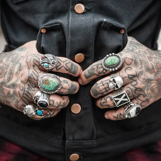 Charlie's tattoo studio, tattooed hands with rings and leather jacket