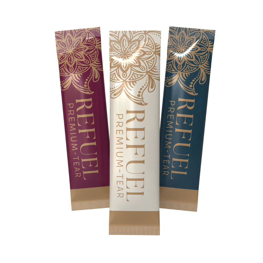 Three REFUEL premium tea sticks in maroon, white, and navy packaging with gold floral designs.