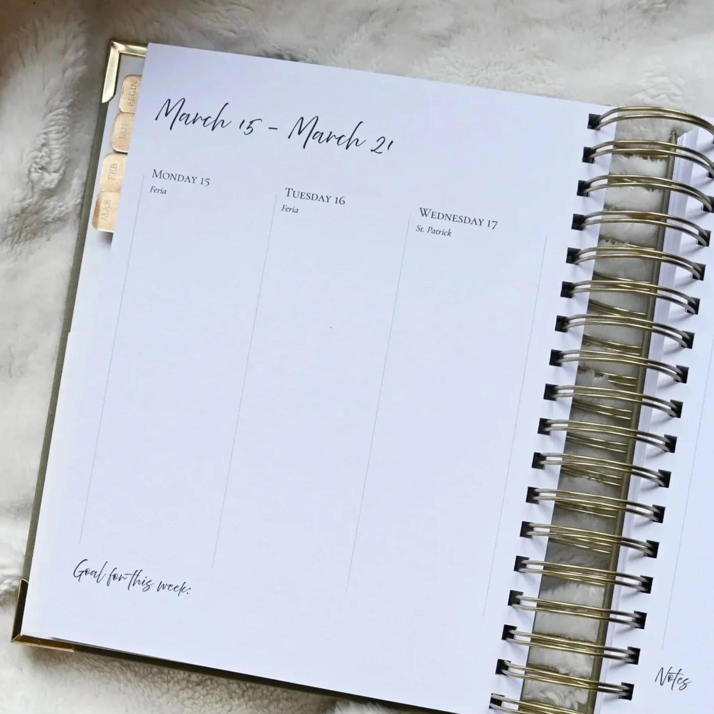 Weekly planner open to March 15 to March 21, with days Monday through Wednesday visible, listing dates and events, on a white marble surface.