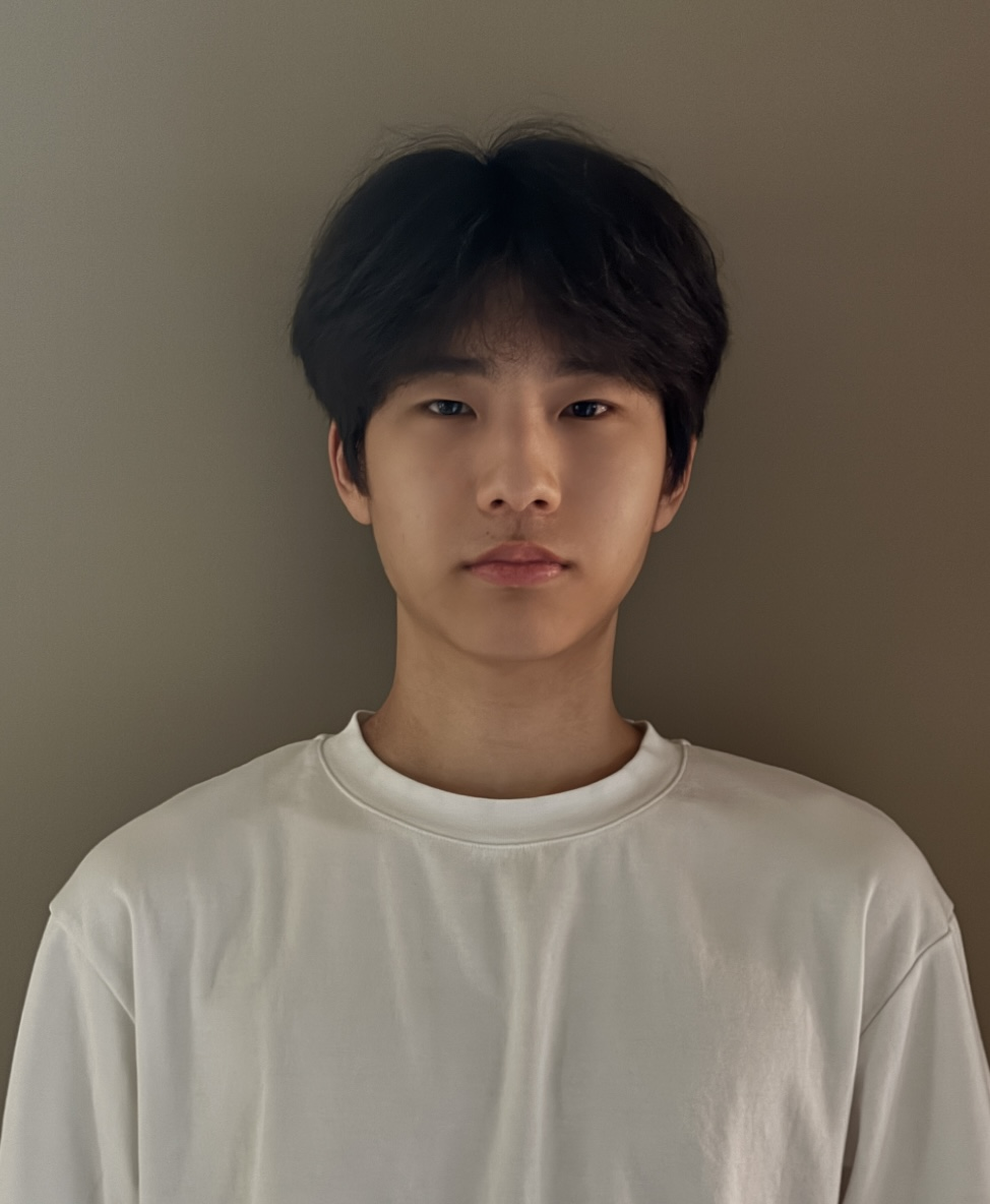 Asian young man with black hair wearing a white t-shirt standing against a plain neutral background.