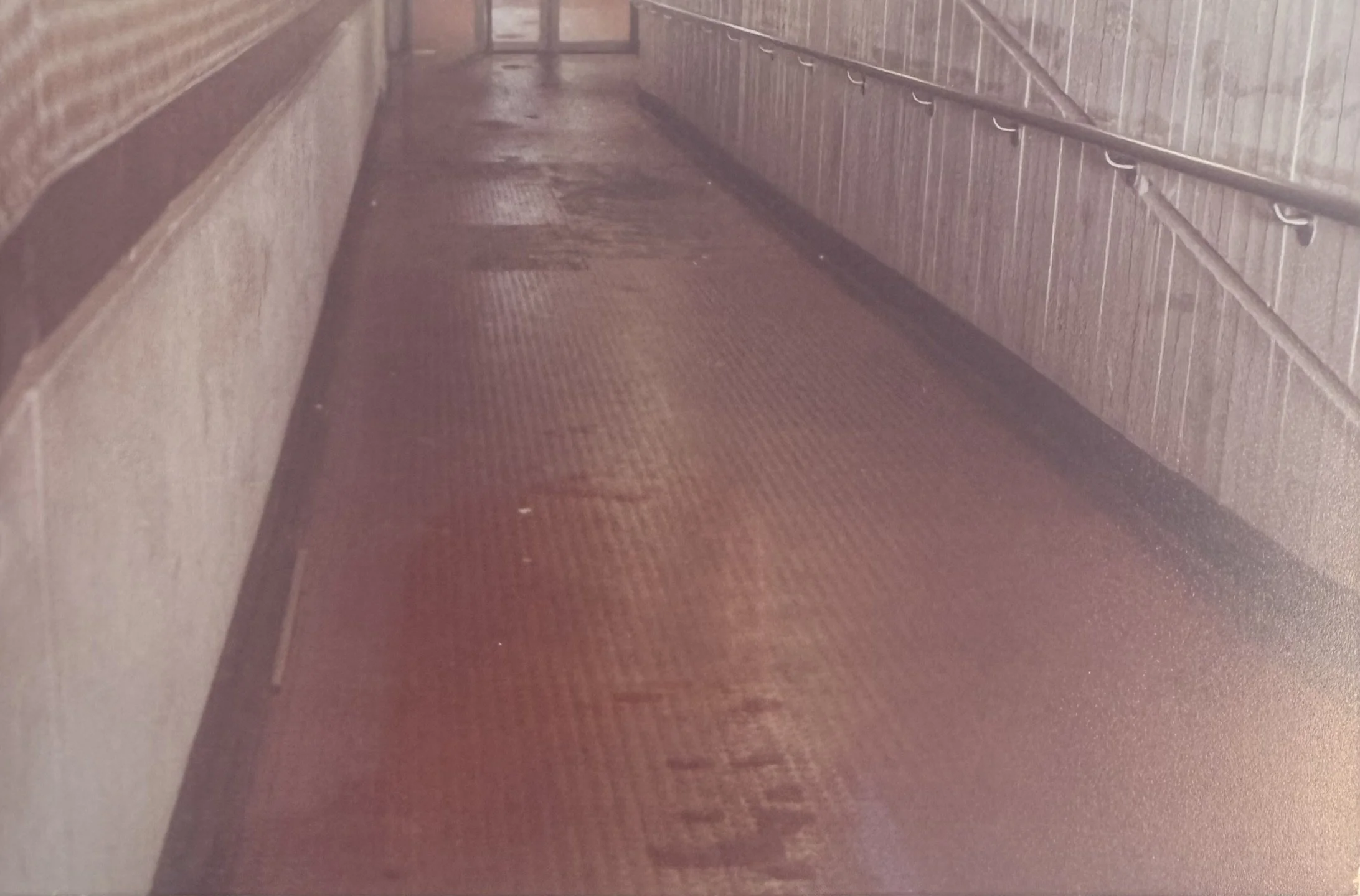 Missing floor tiles and grubby walls on ramp