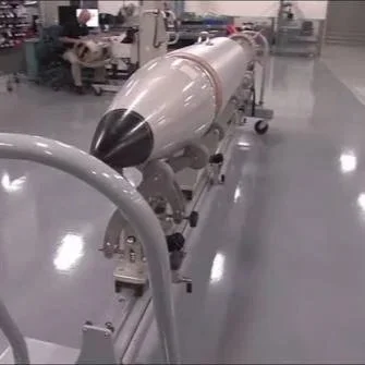 A large missile or torpedo in a manufacturing or testing facility.