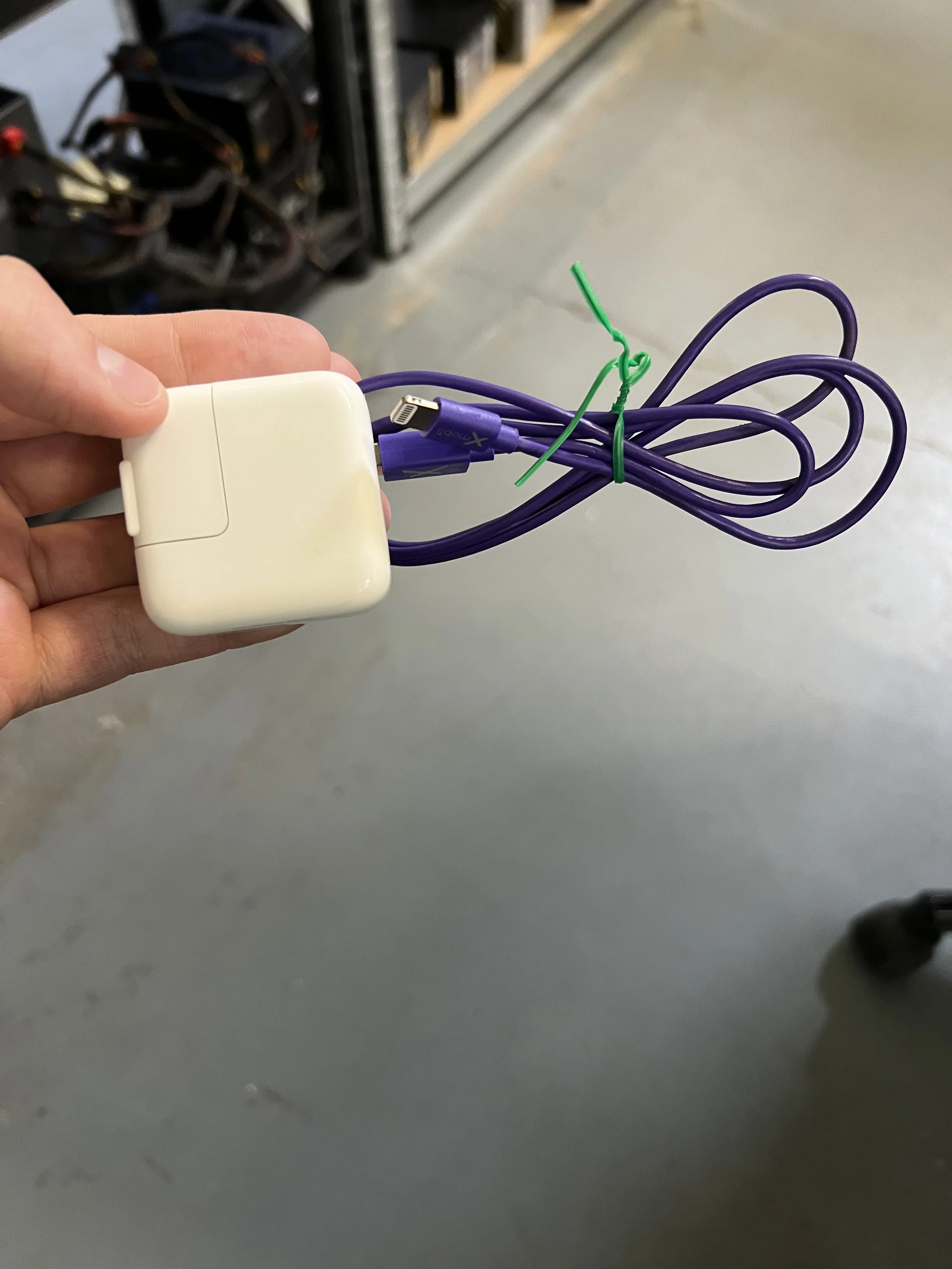 Apple 5W USB Power Adapter (Model A1385) paired with a third-party purple USB-A to lightning cable.