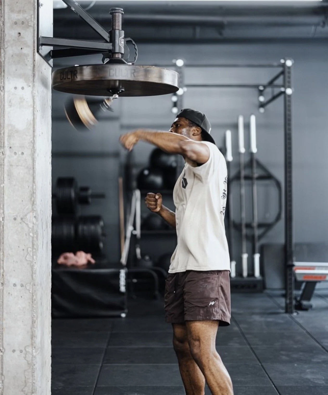 Athlete striking a spinning wooden double-end bag during a boxing workout in a gym