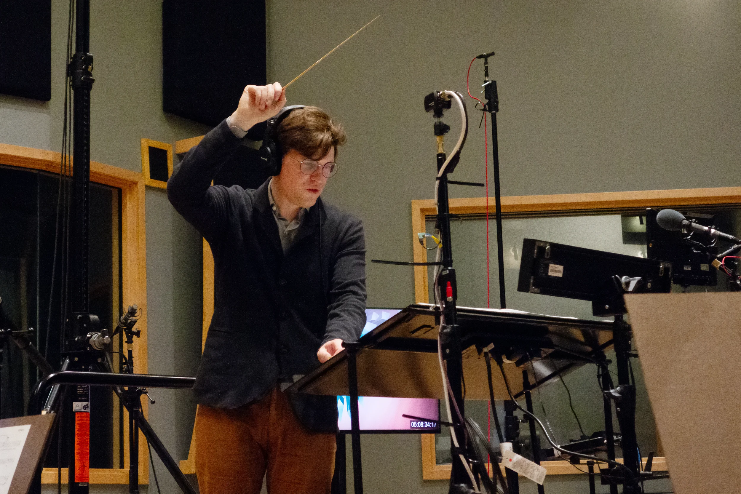 Joshua Moshier raising his baton in a sound studio.