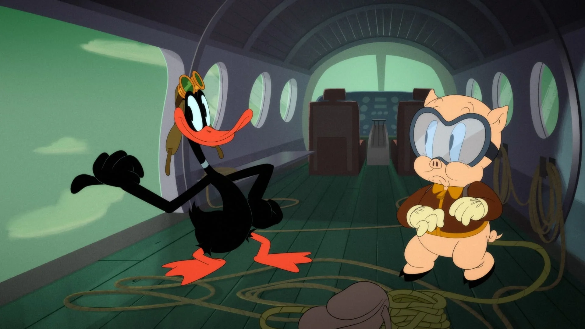 Daffy Duck and Porky Pig wearing flight goggles inside an airplane cargo hold.