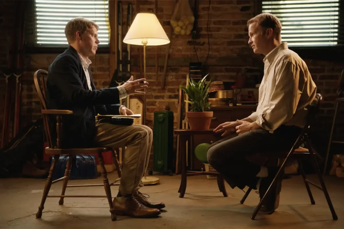 Tim Baltz as David Trace holding a notepad while conducting a therapy session in a garage in Shrink.