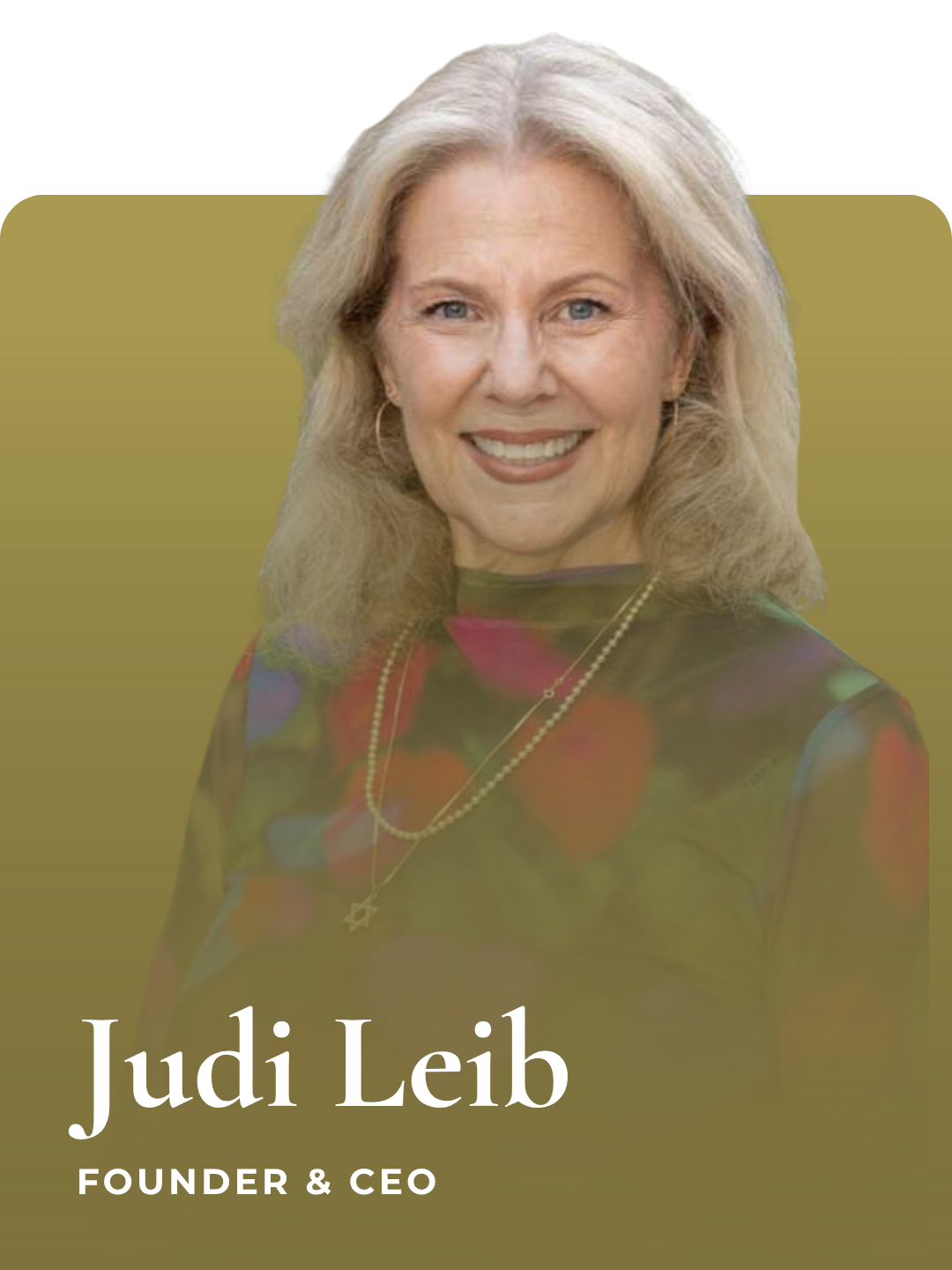 Portrait of Judi Leib, founder and CEO, smiling with blonde hair, wearing a colorful top and necklaces, against a plain background.