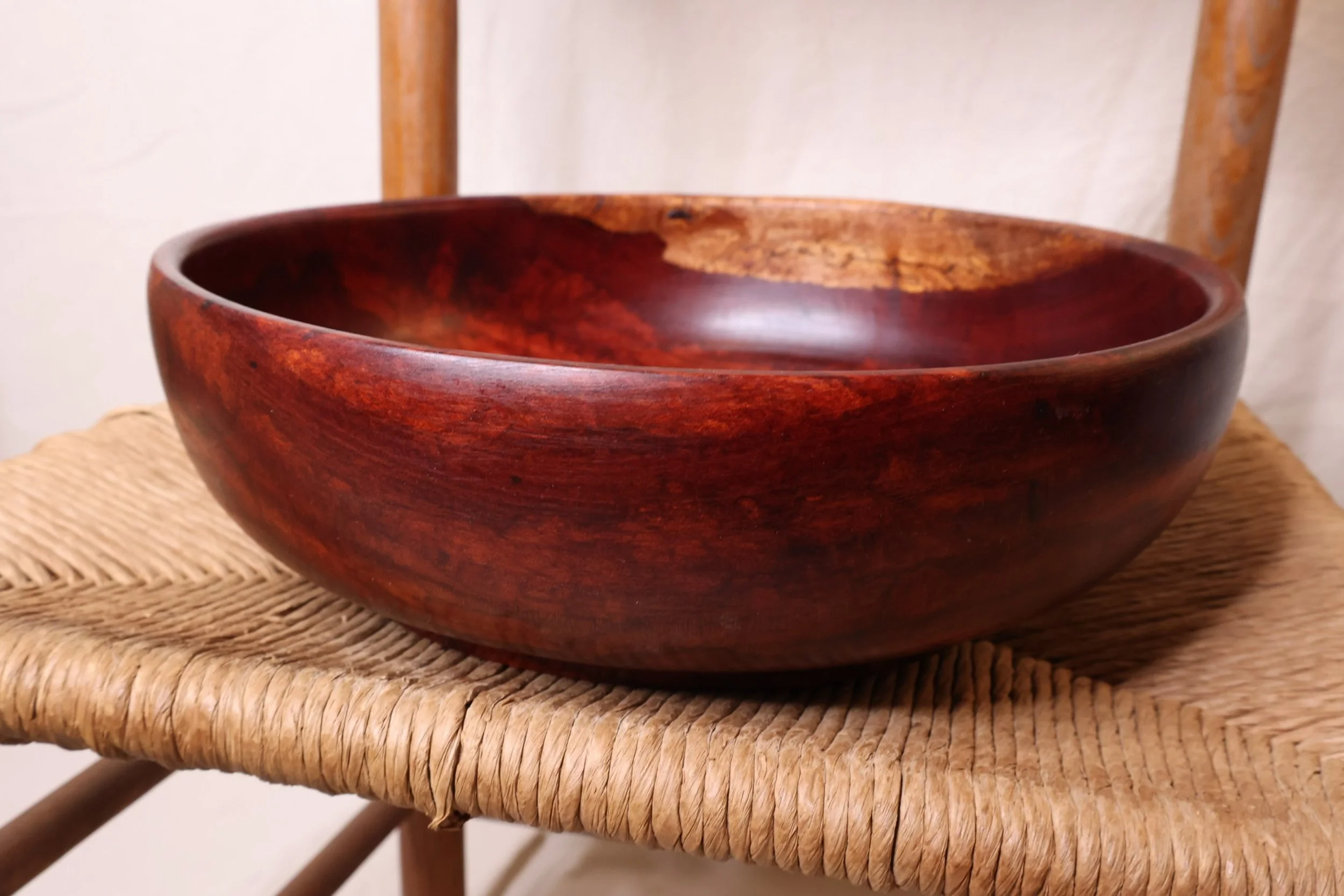 Bring midcentury warmth and organic sculptural form to your space with this 1970s turned wood bowl. Crafted from solid mahogany, it showcases a rich and deep reddish-brown grain with subtle golden undertones, strikingly contrasted by a unique band of