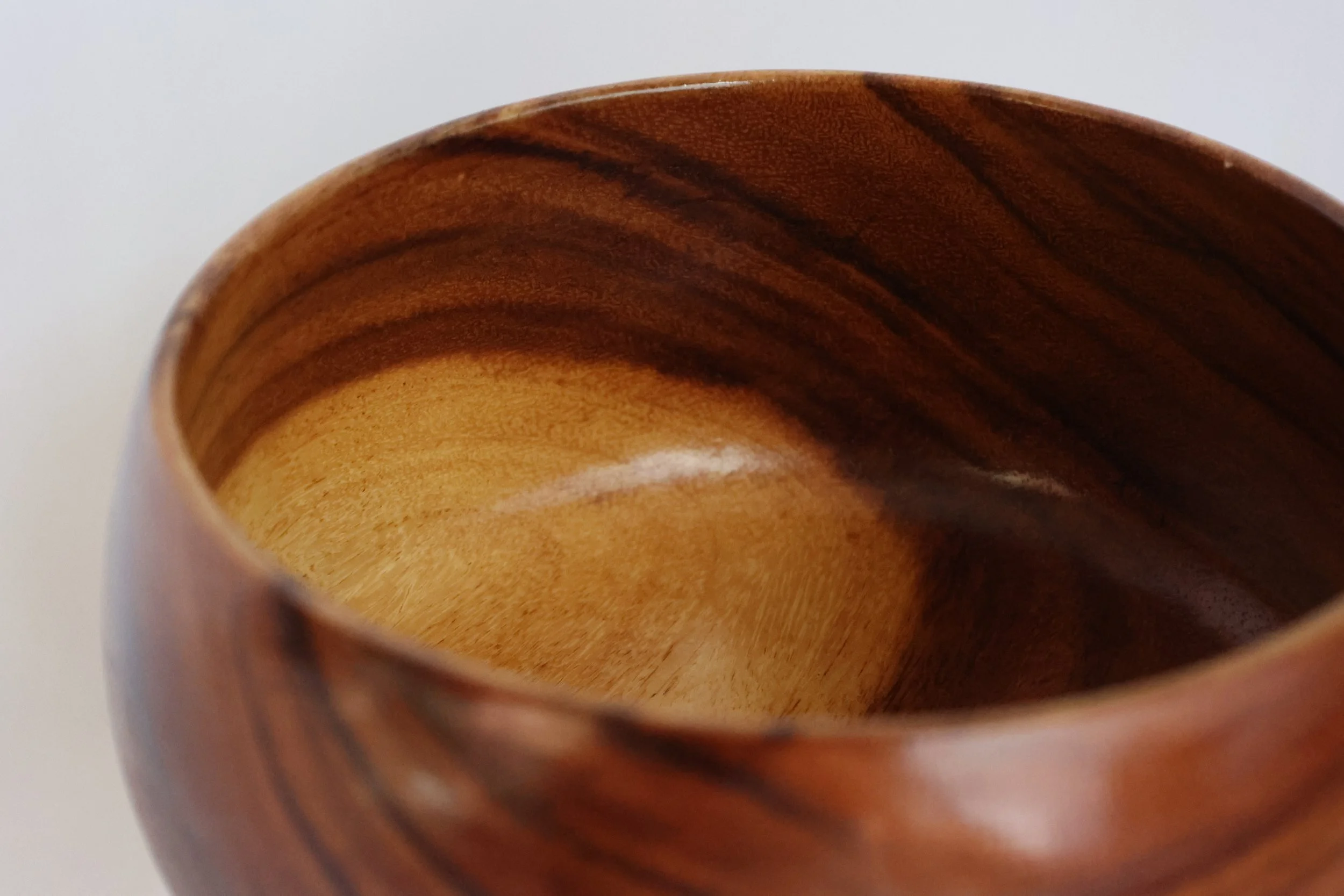 This dainty yet hearty fruits bowl is crafted from a lovely two-toned teak, and sits at 13 cm tall with a base width of 11.8cm, expanding to 20.5cm at its widest. The wood has been skillfully turned down to a gauge of approximately 6mm all around. Da
