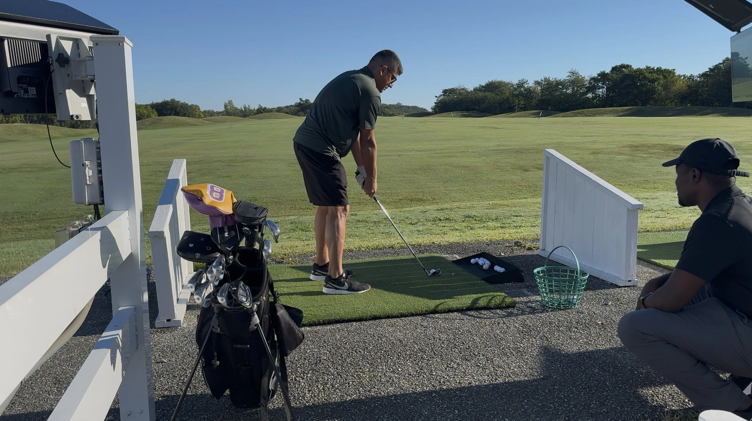 Client moving independently on a golf course while a physical therapist observes.