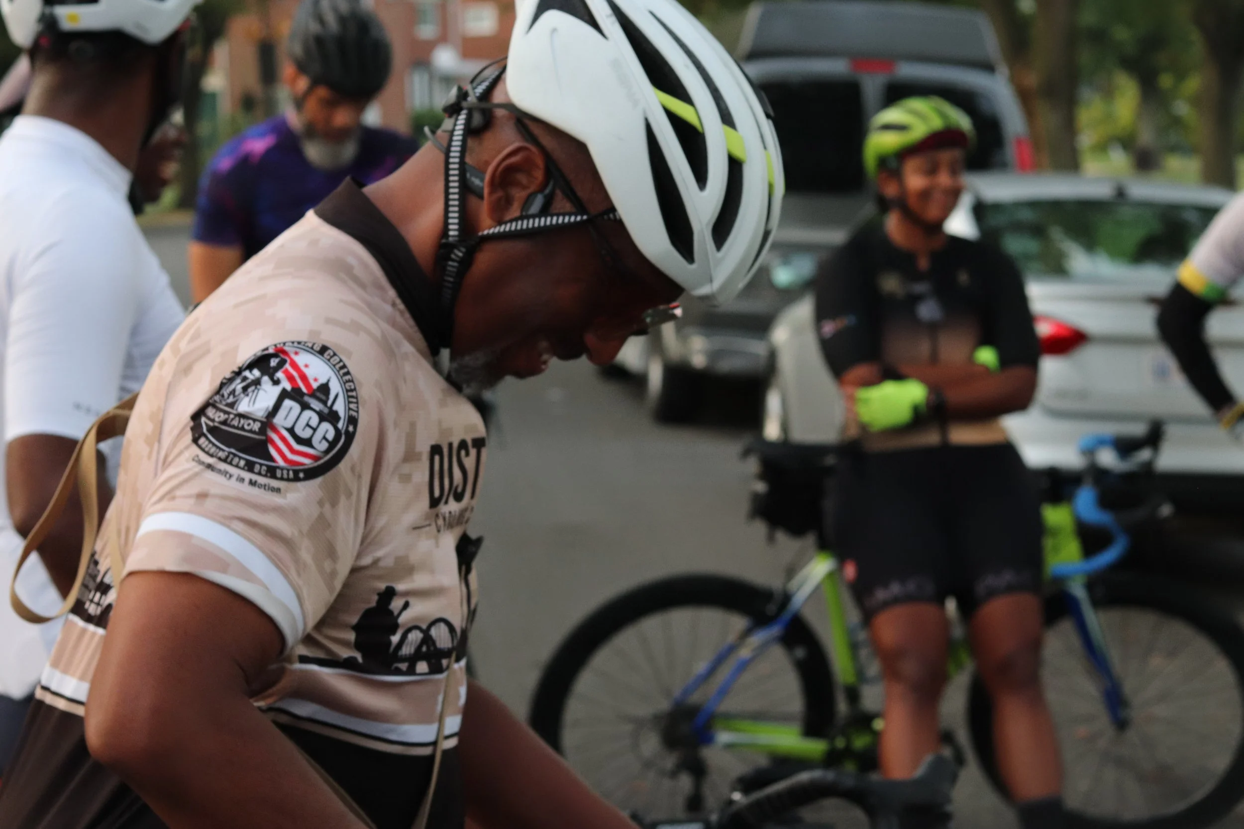 Cyclist talking with members of his group before a ride.