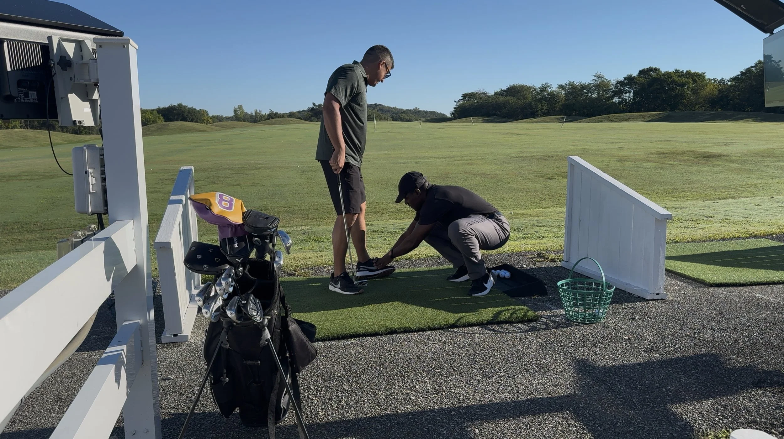 Physical therapist assesses a golfer’s ankle mobility on a golf course while the golfer observes.