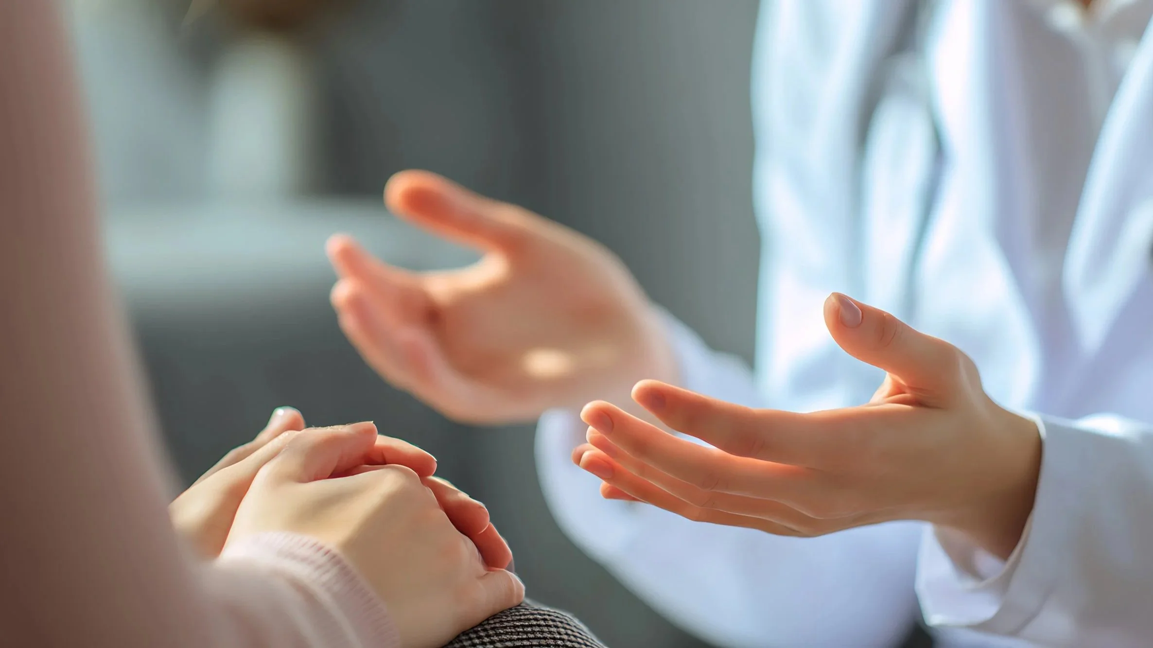 A professional clinician using their hands to express while offering care