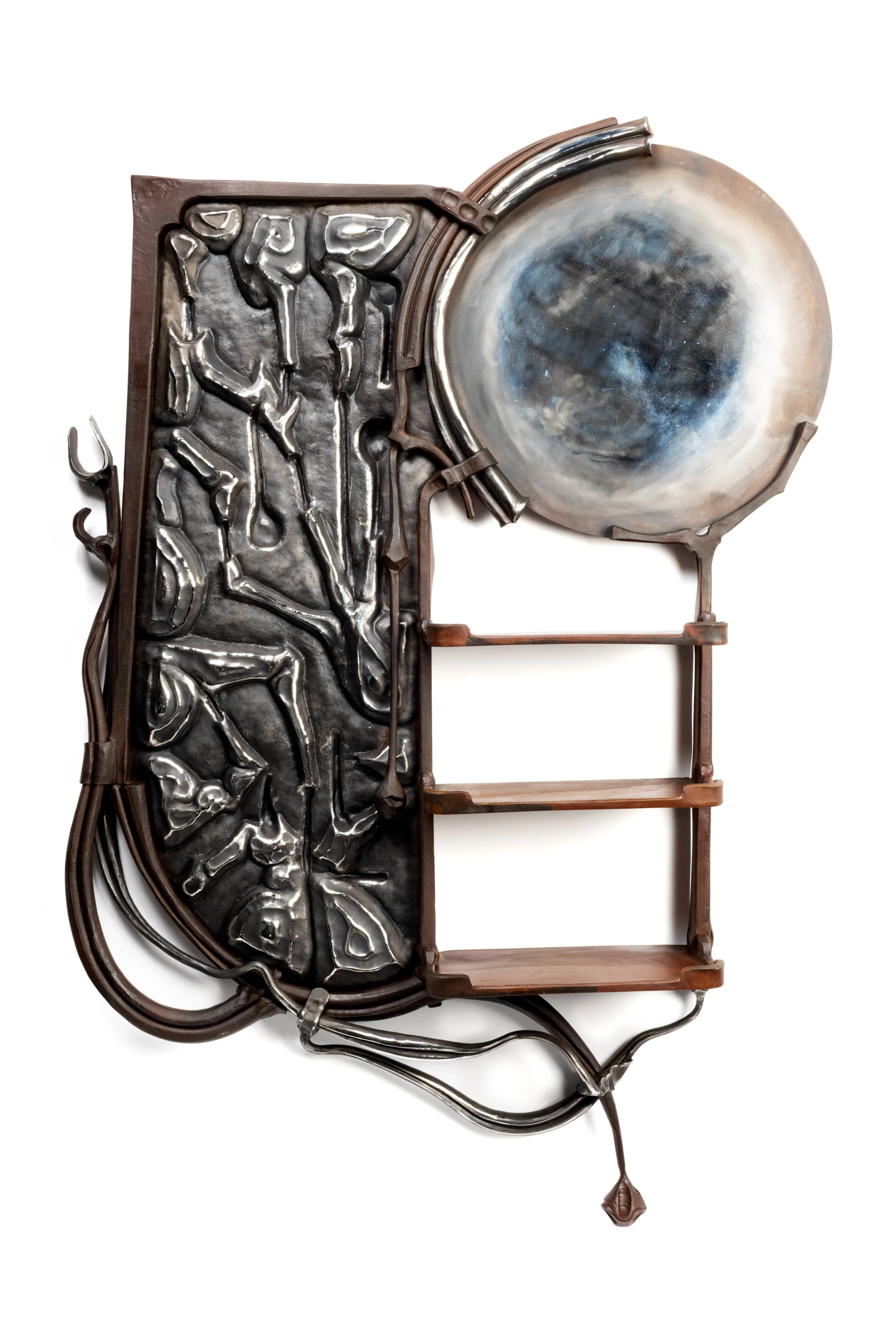 Mixed-metal sculpture combining a formed dark metal panel with abstract figures and a large circular, polished metallic element with cloud-like textures, supported by a brown steel frame.