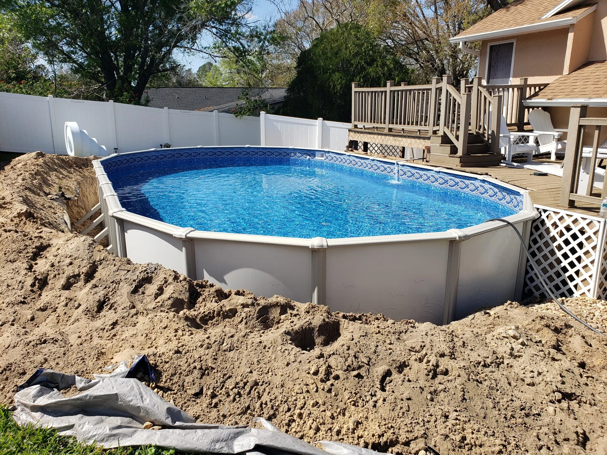 Above-ground swimming pool installation with surround deck.