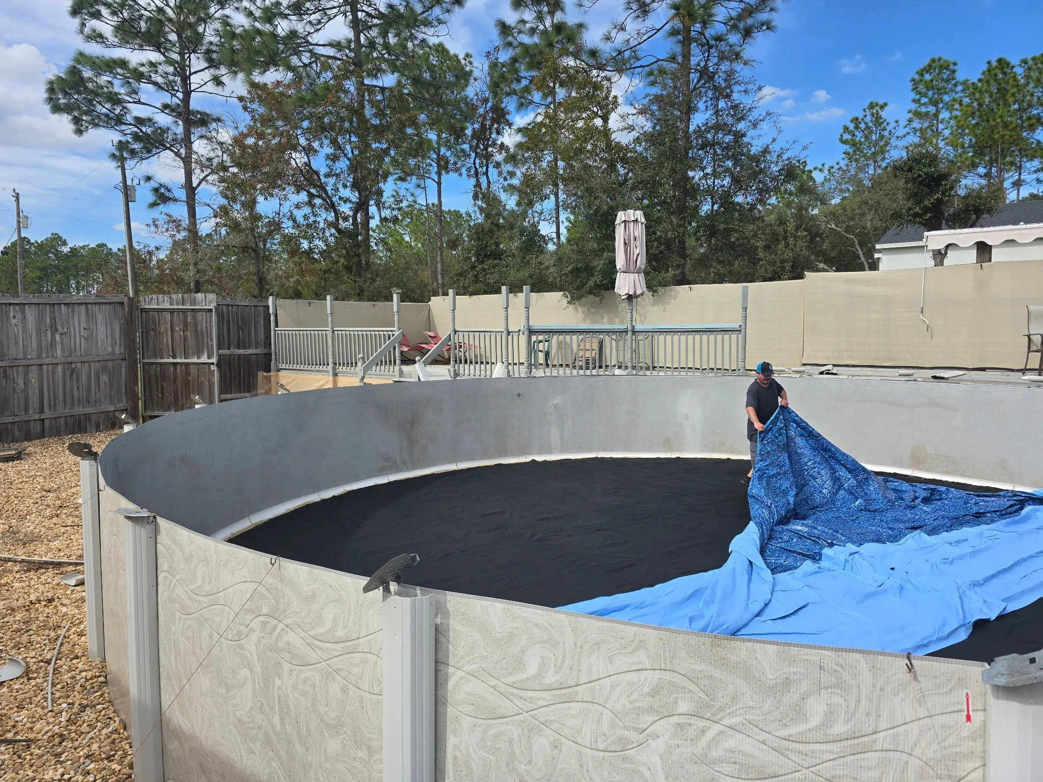 Above-ground liner replacement in progress with blue liner being installed.