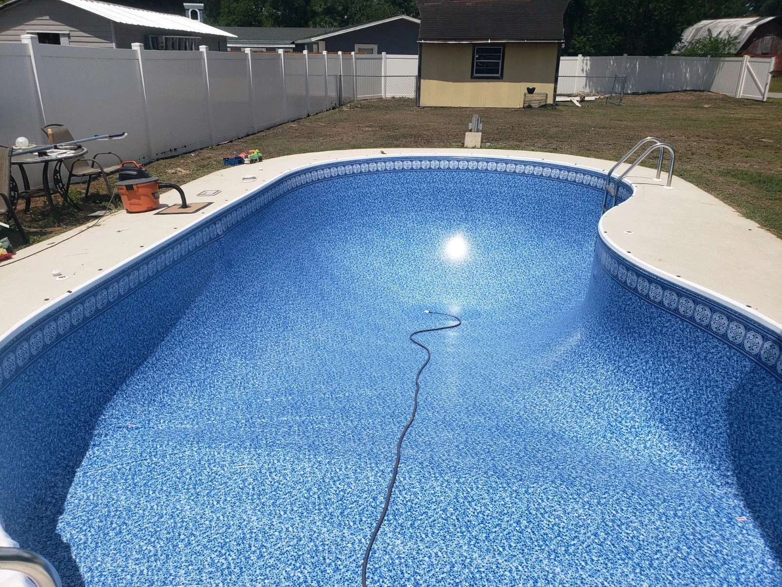 Inground swimming pool with blue patterned liner during liner replacement.