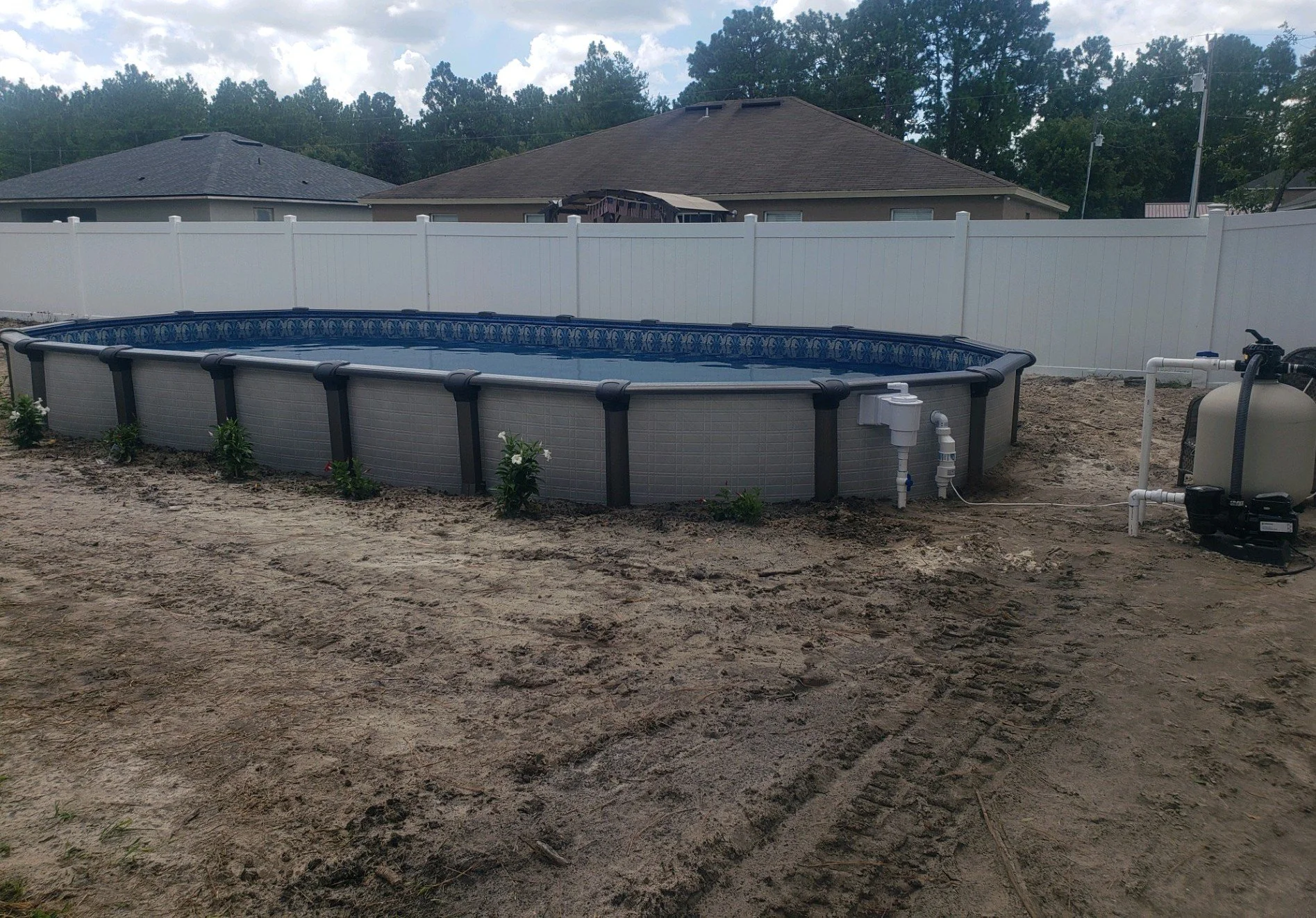 Completed above-ground swimming pool installation with blue liner.