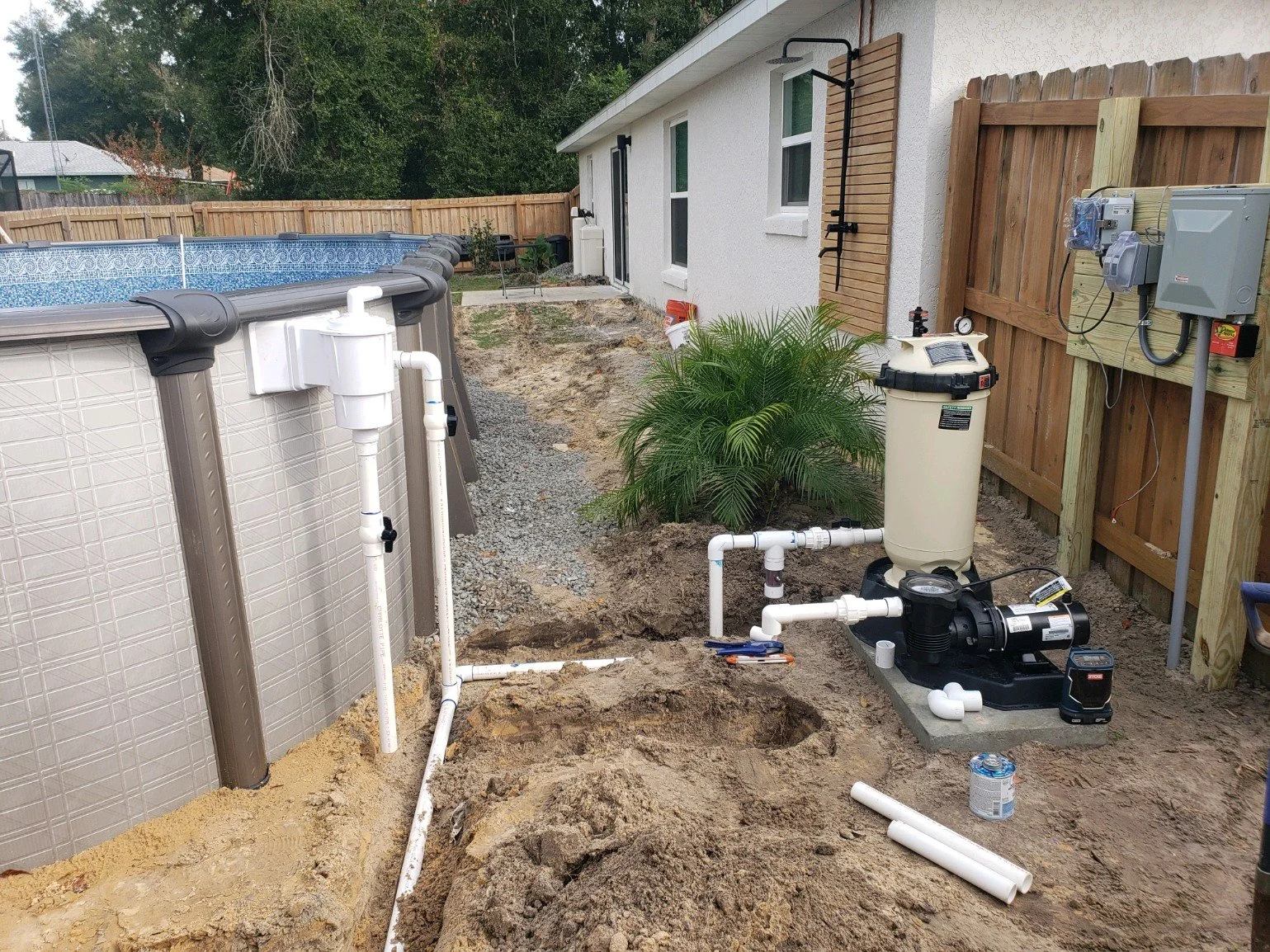 Above-ground pool pump, filter and plumbing installation in progress.