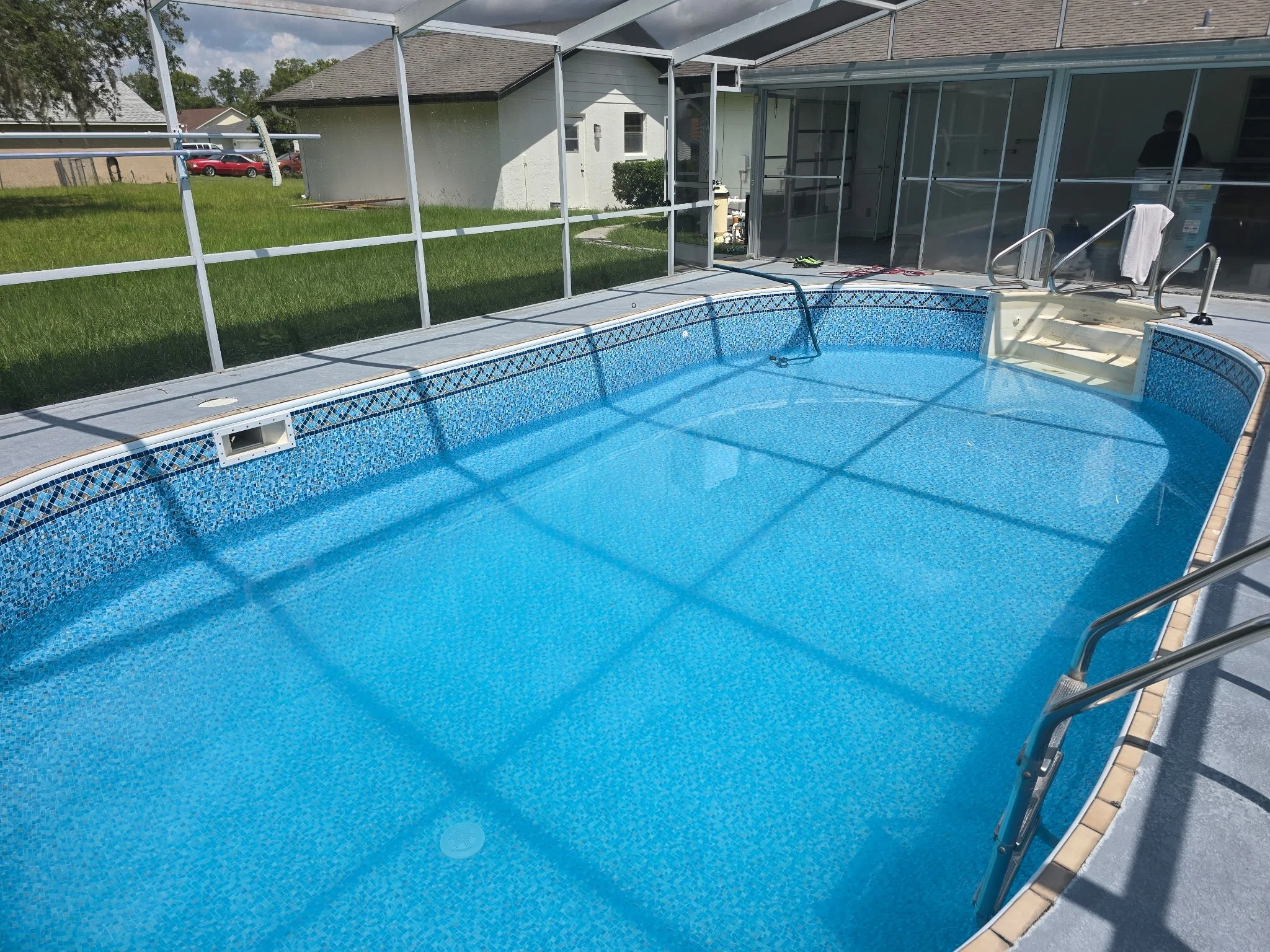Inground swimming pool with new blue liner, steps and screened enclosure. 