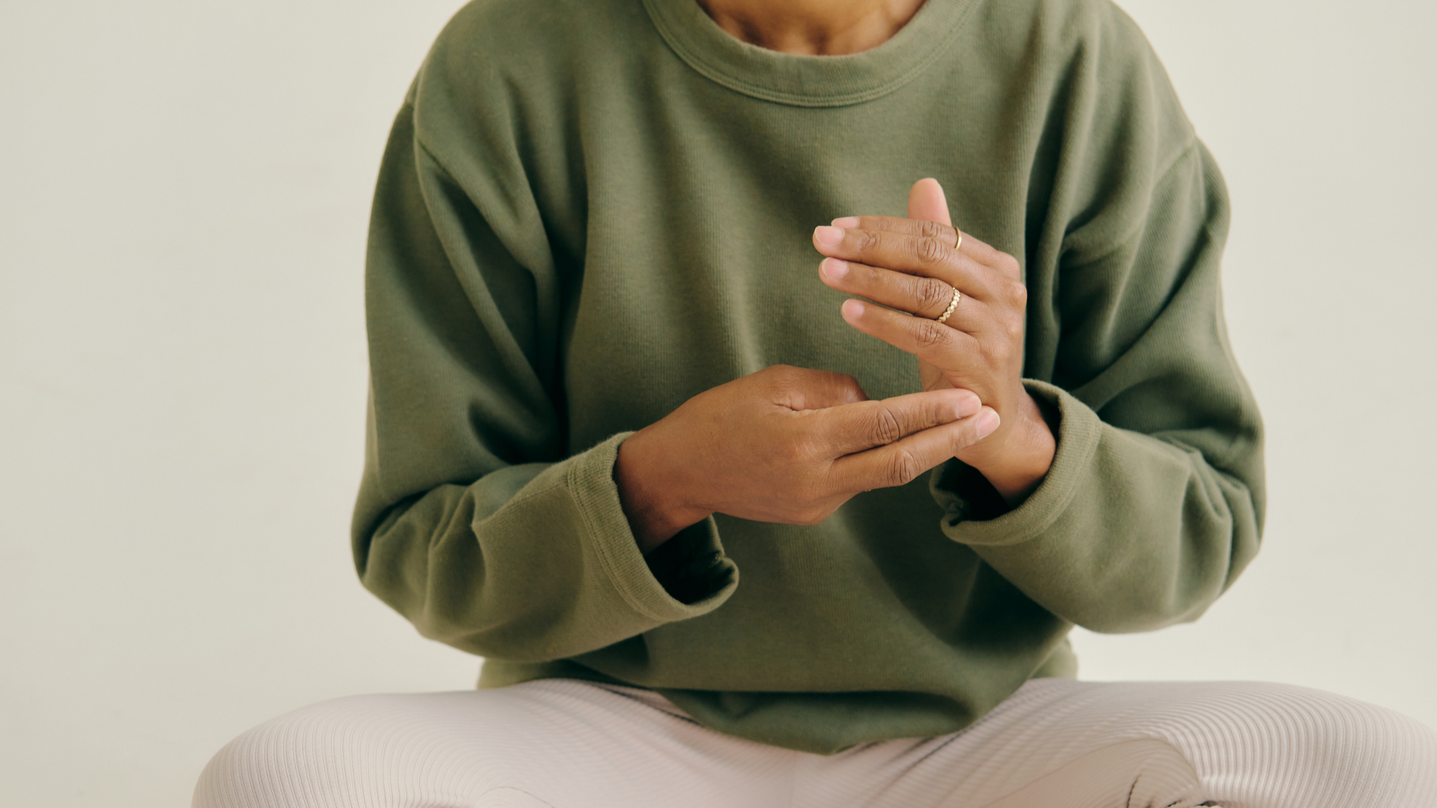 Person sitting cross-legged, doing tapping motions as part of online therapy for OCD, anxiety, and trauma in Arizona.