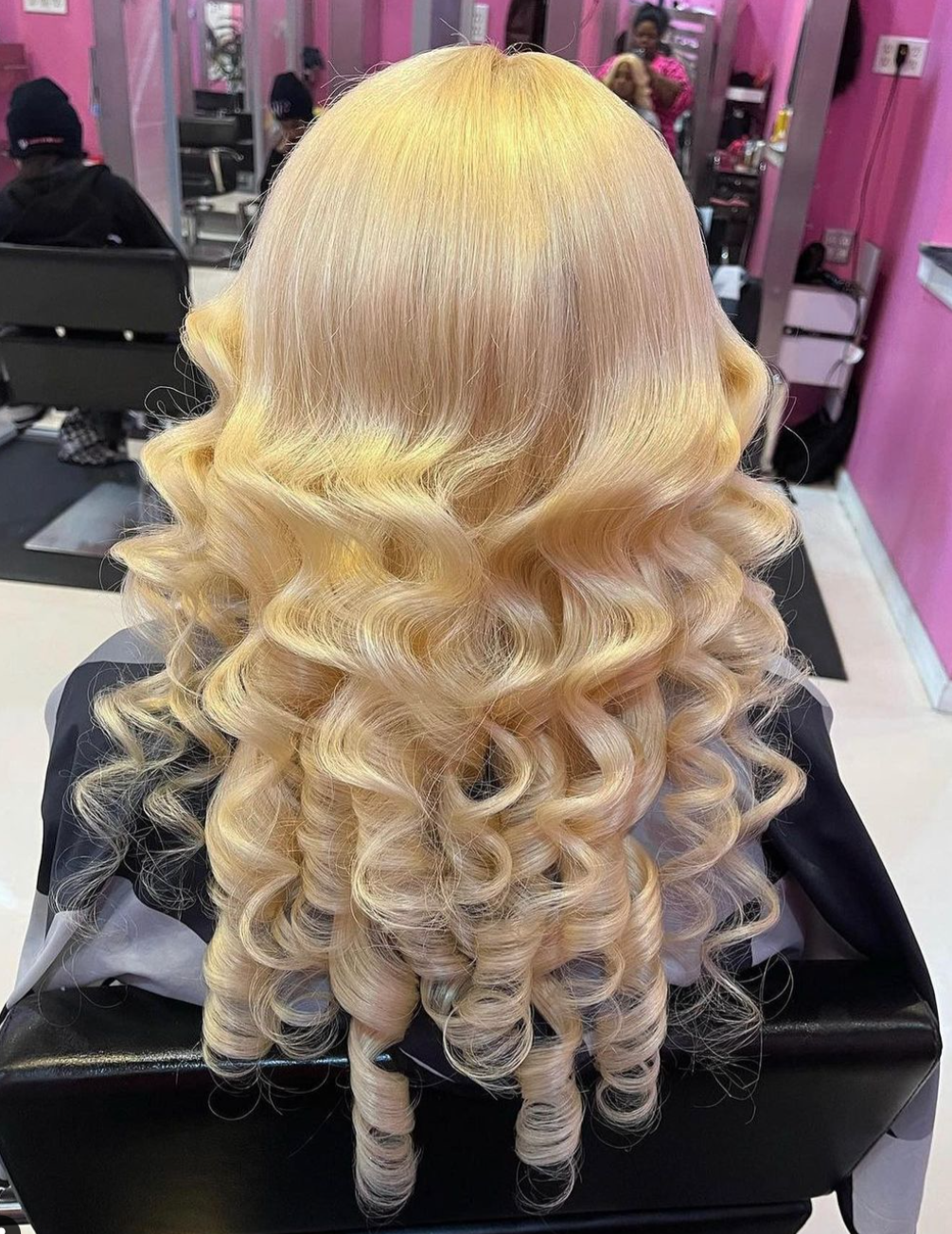 Salon de Weave client showcasing long blonde hair with smooth, voluminous curls and a polished professional finish.