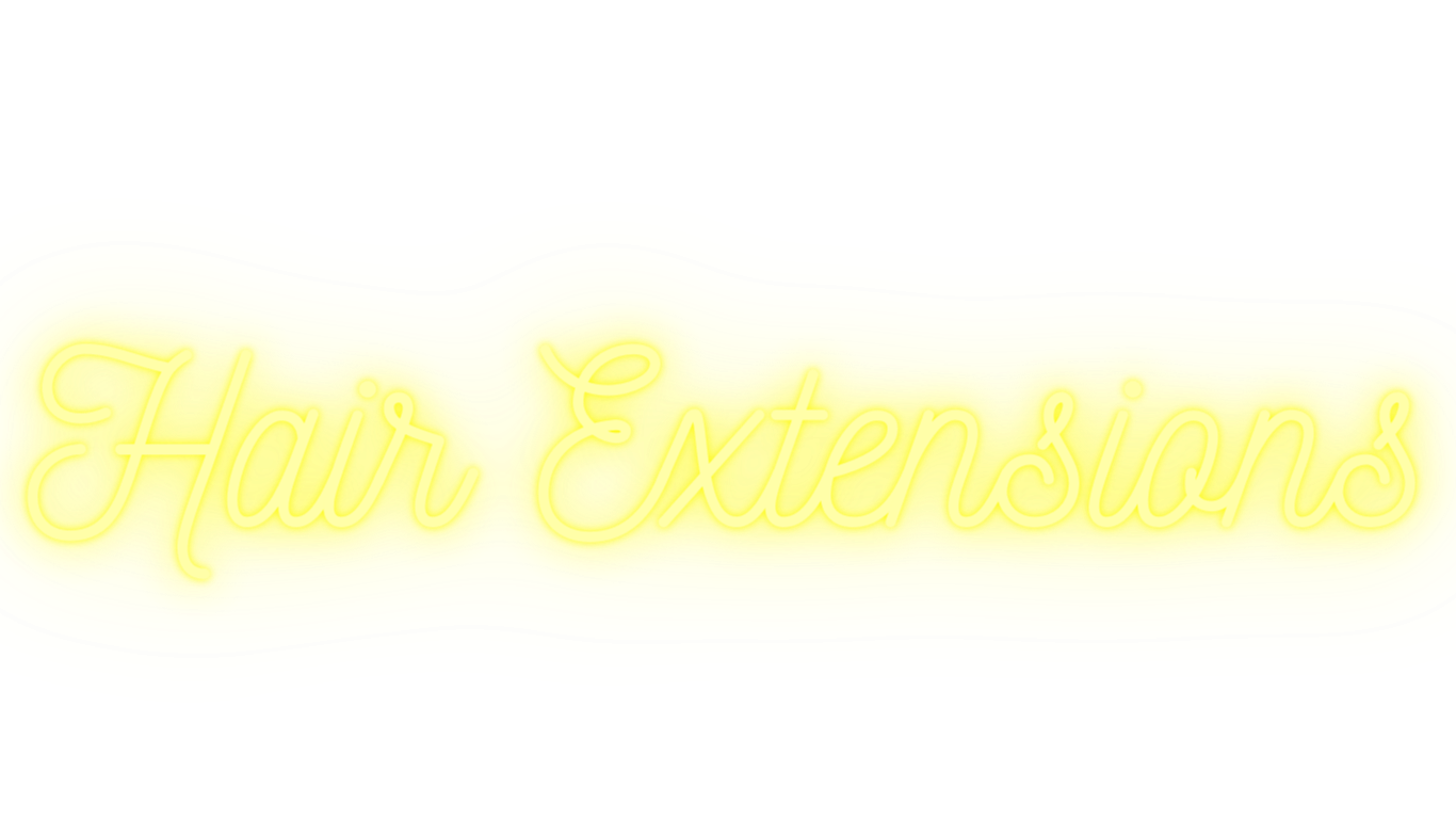 Bright yellow sign with the white cursive text 'Hair Extensions' in front of a black background.