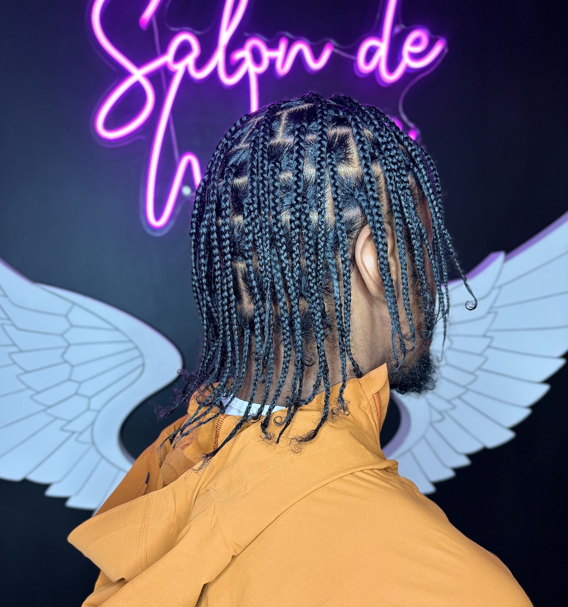 Salon de Weave client showcasing professionally styled men’s individual braids with clean, defined parting.