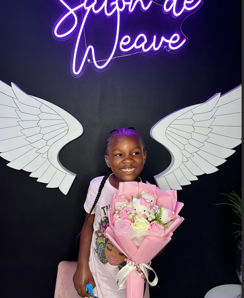 Young client showing her finished braided hairstyle at Salon de Weave