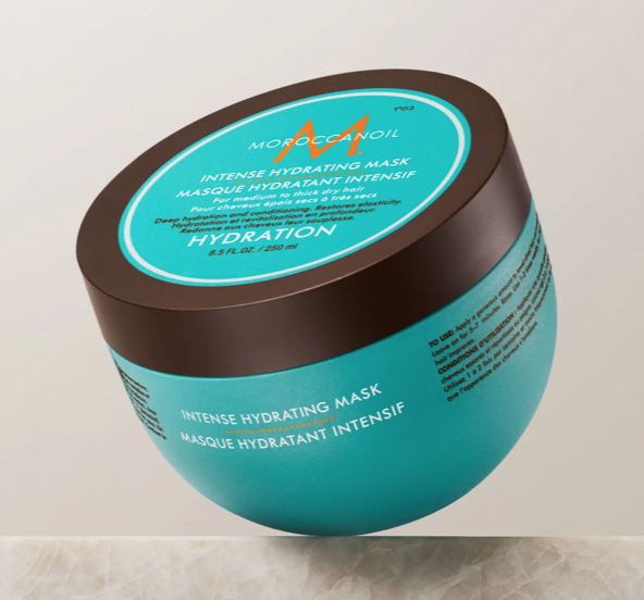 MOROCCANOIL Intense Hydrating Mask in a blue container with a brown lid, placed on a light surface.
