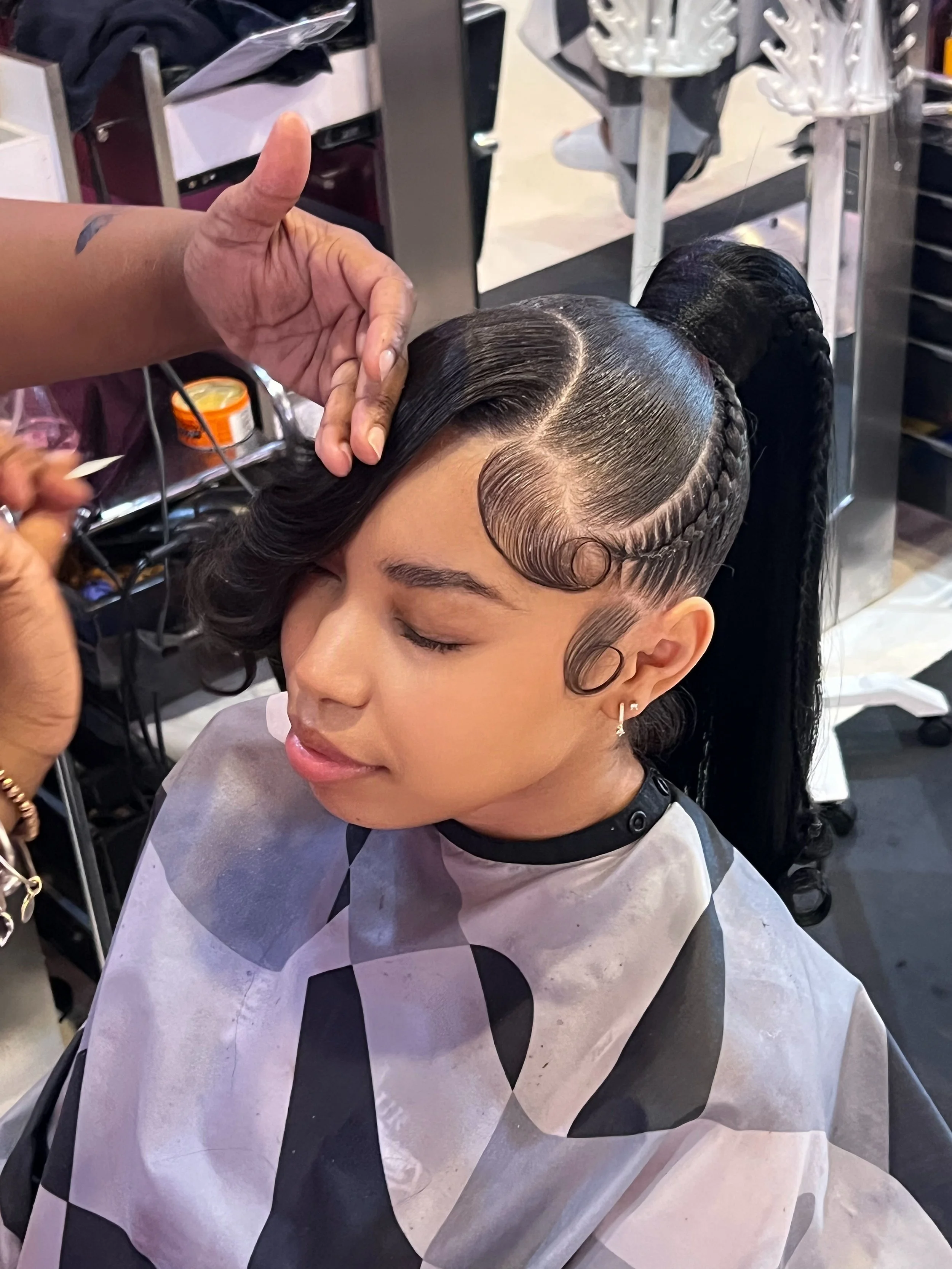 Stylist creating an Up-Down Sew-In hairstyle at Salon de Weave.