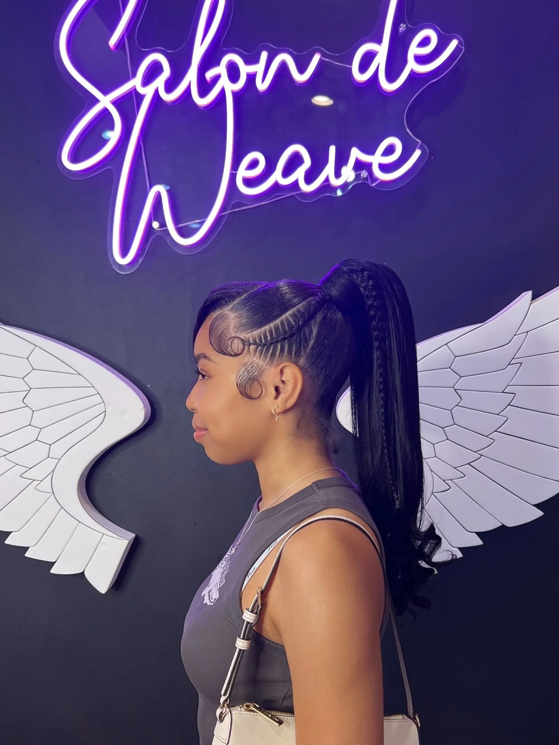 Client wearing a sleek high braided ponytail with styled baby hairs at Salon de Weave.