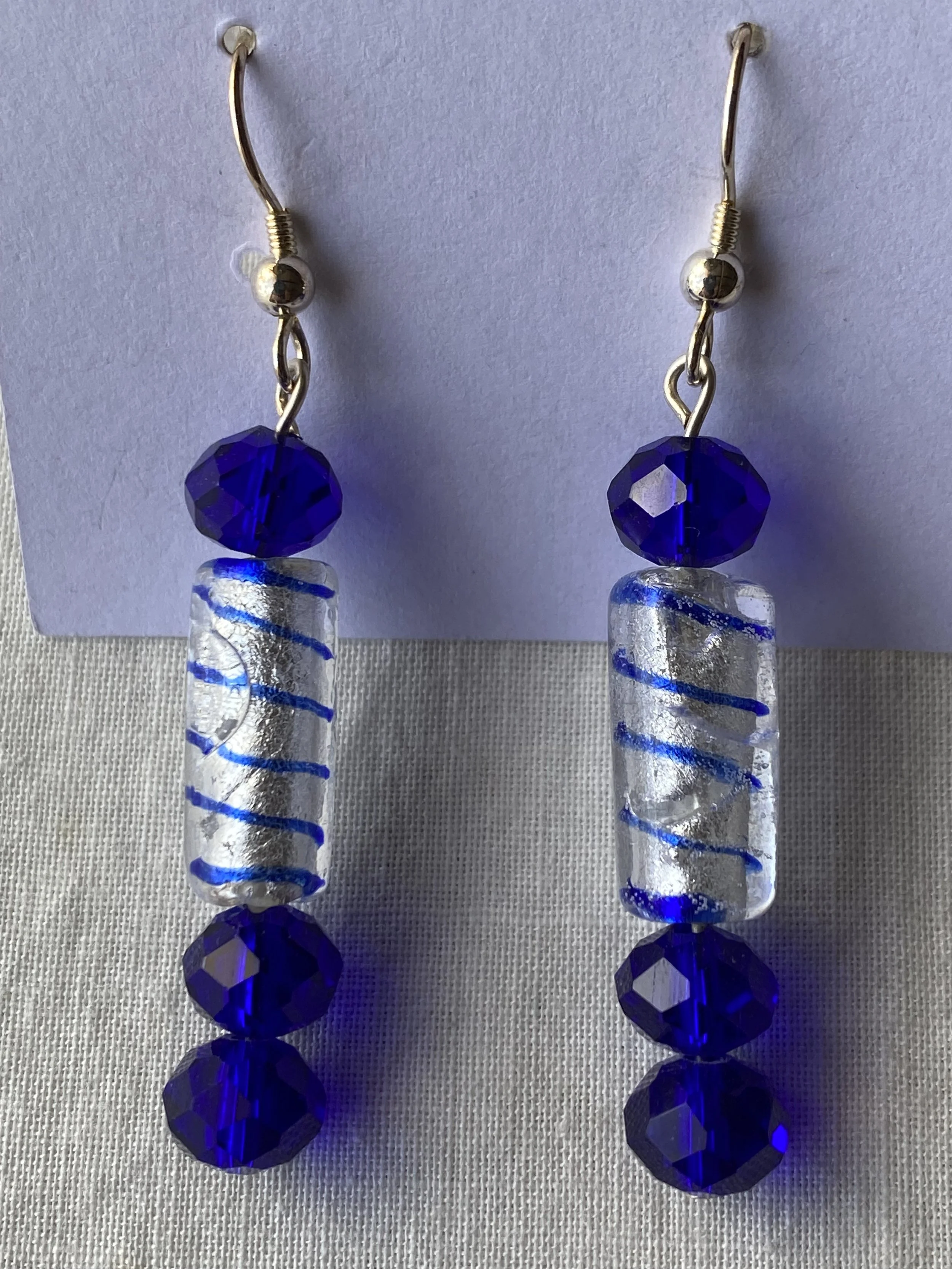 Pair of dangle earrings with blue and clear glass beads on a white background.