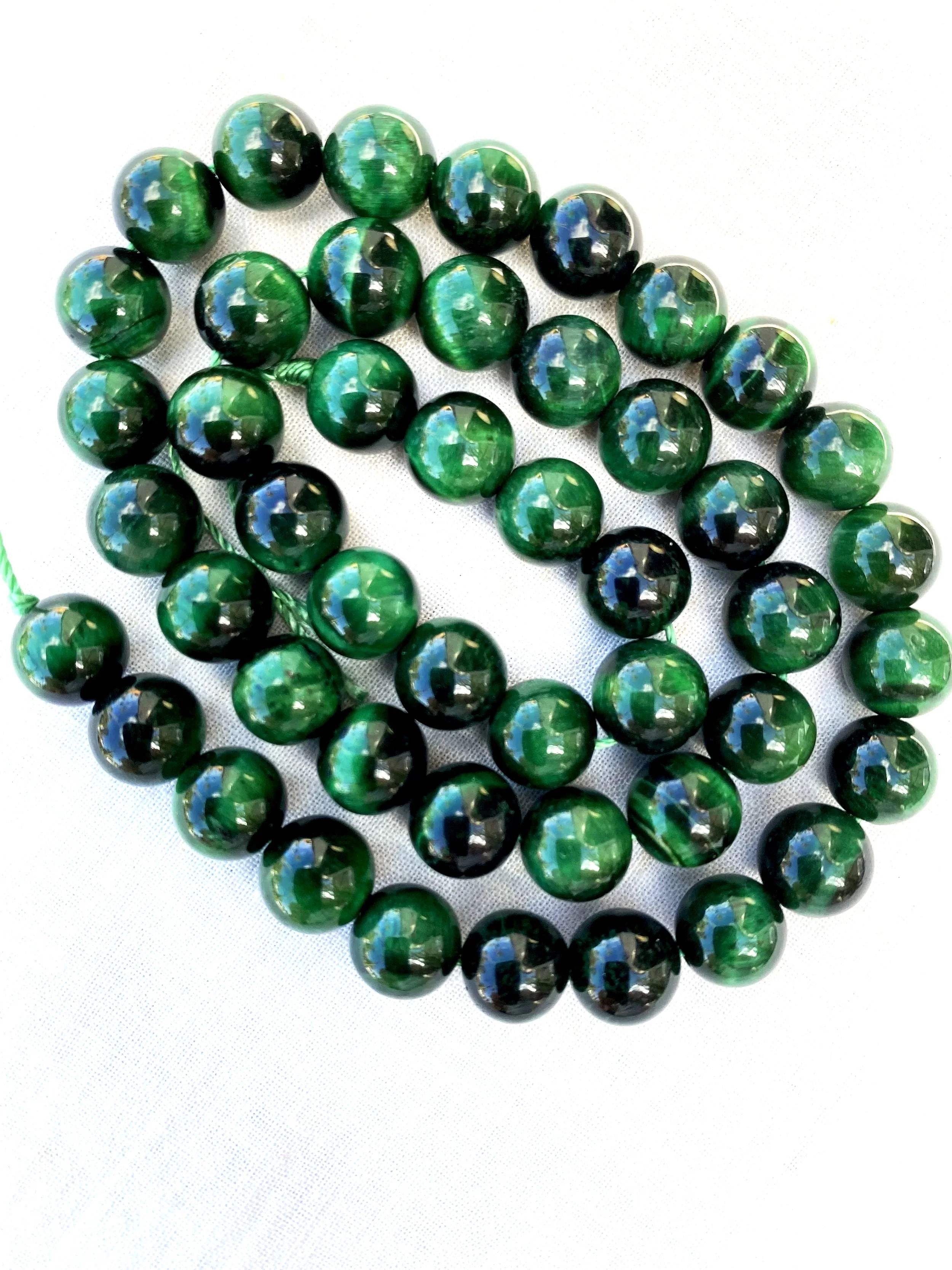 String malachite beads arranged on a white surface.