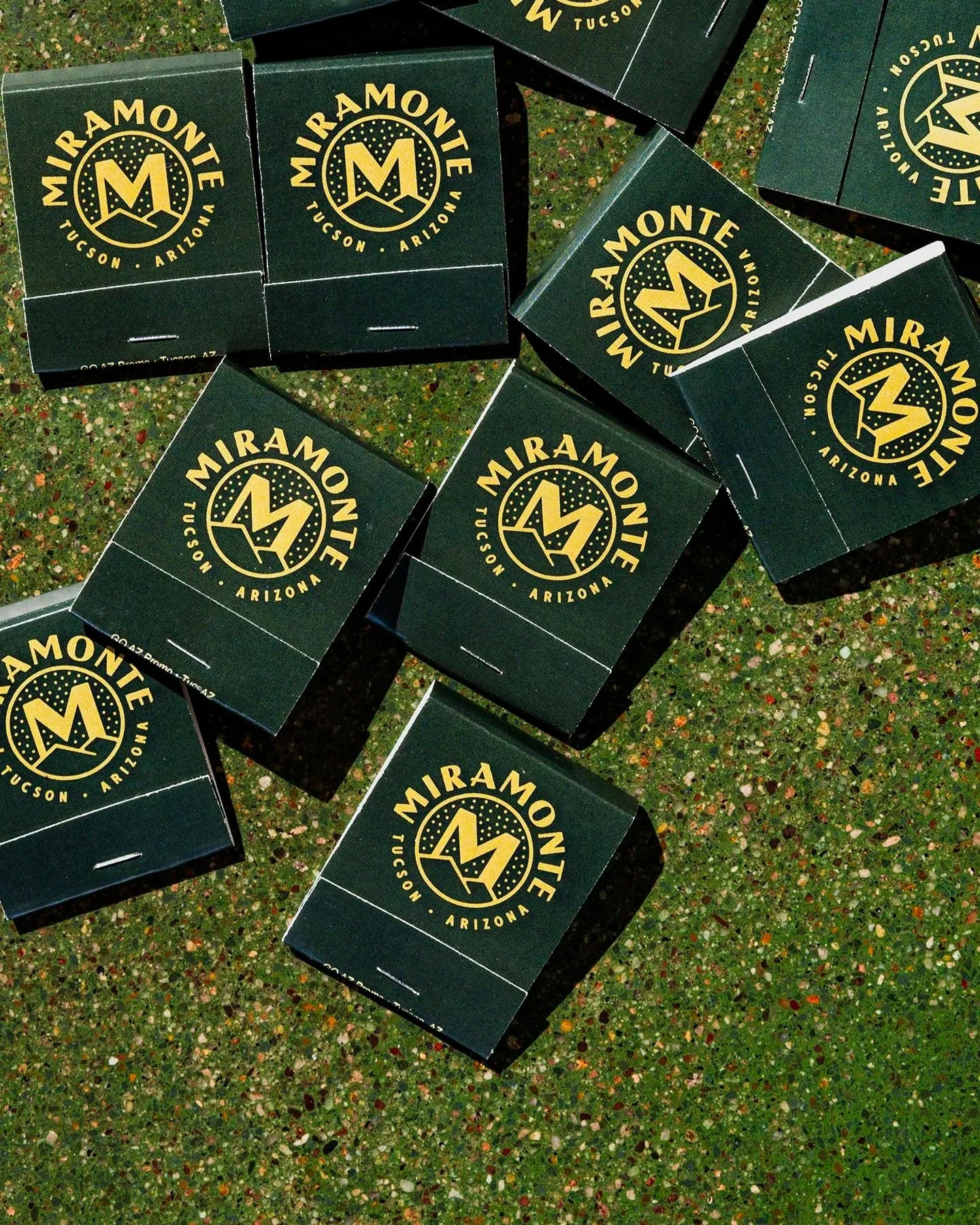 Multiple matchboxes with the Miramonte logo, arranged on a multicolored speckled surface.