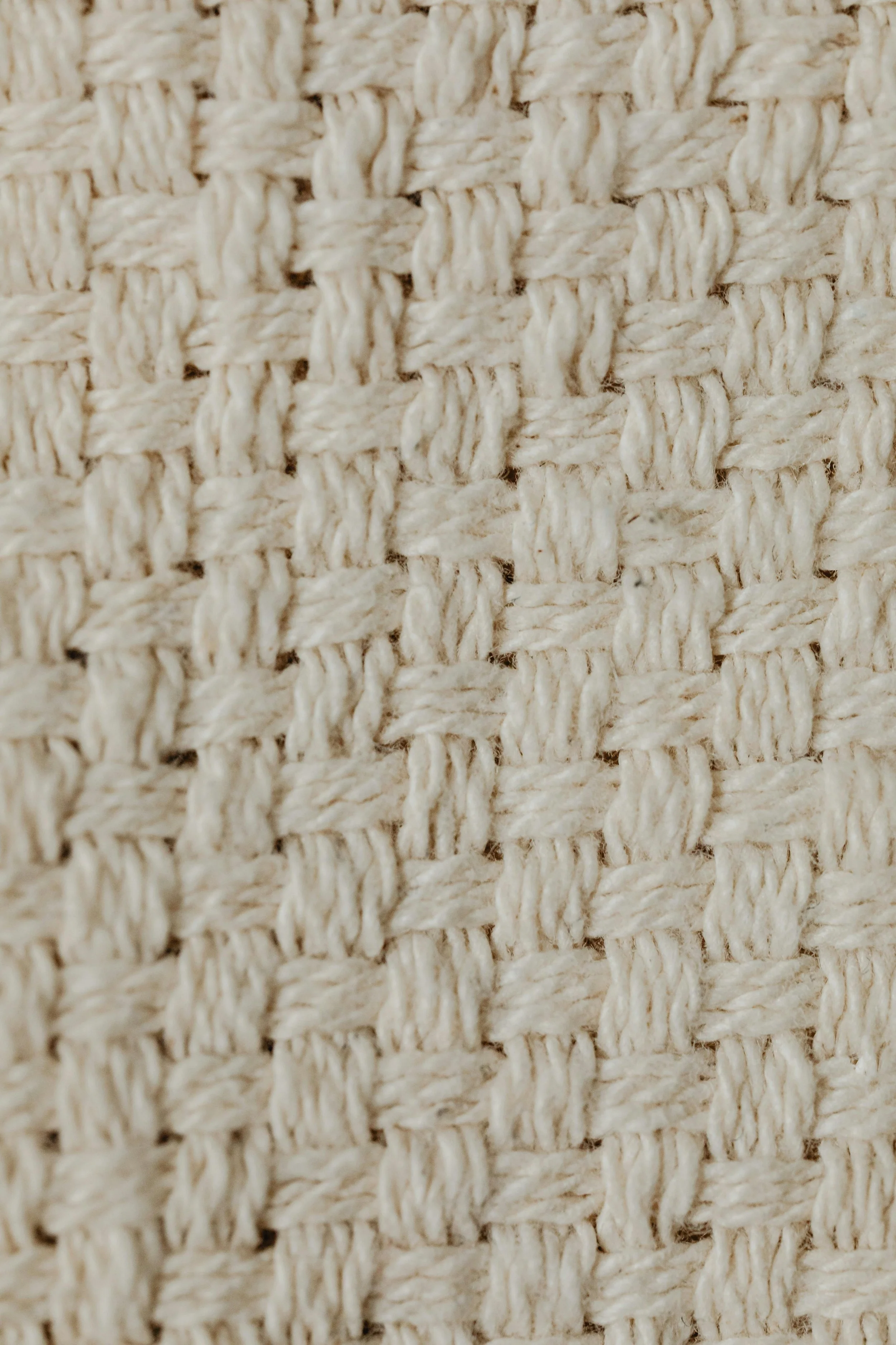Macro de uma trama de tecido ou rede feita de fibras naturais, com padrão de nós entrelaçados.